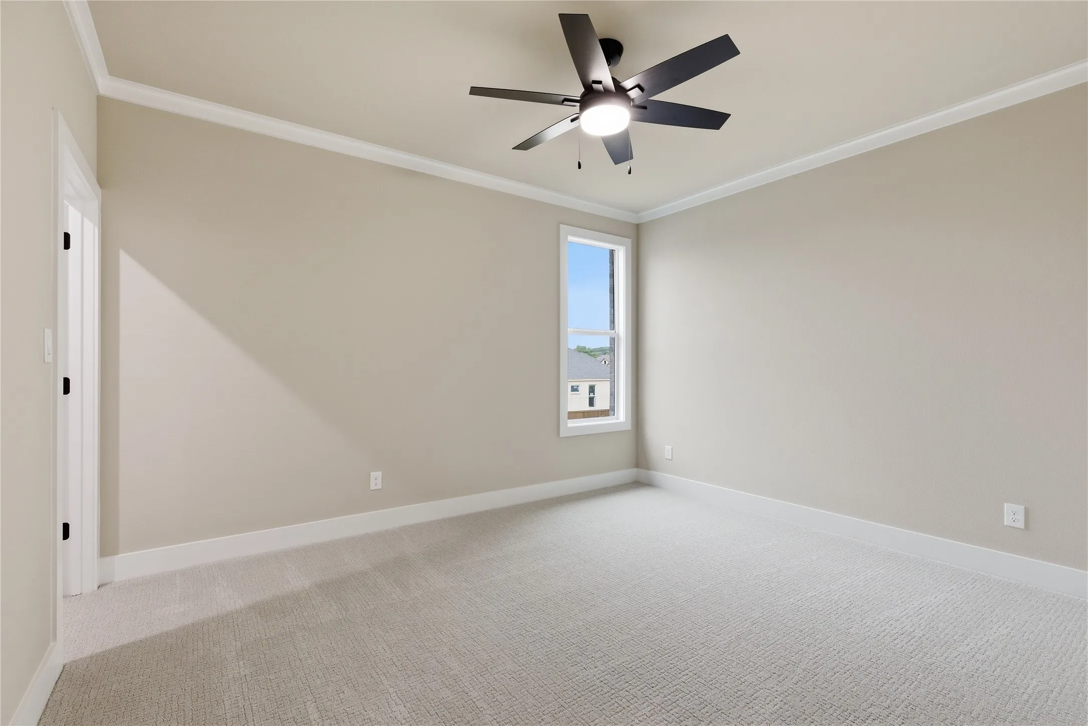 Carpeted room featuring a single window, crown molding, and a ceiling fan with integrated lighting