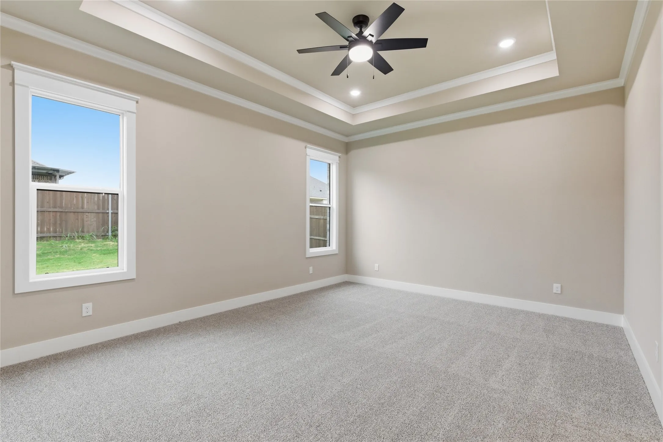 Spacious room featuring light gray carpeting and neutral wall tones