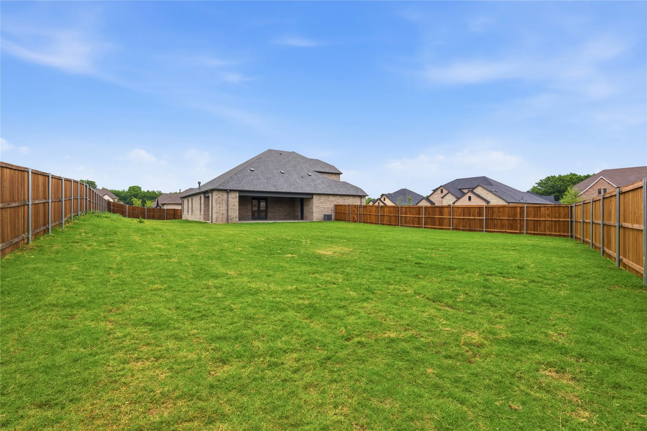 Expansive green lawn with a full wood privacy fence