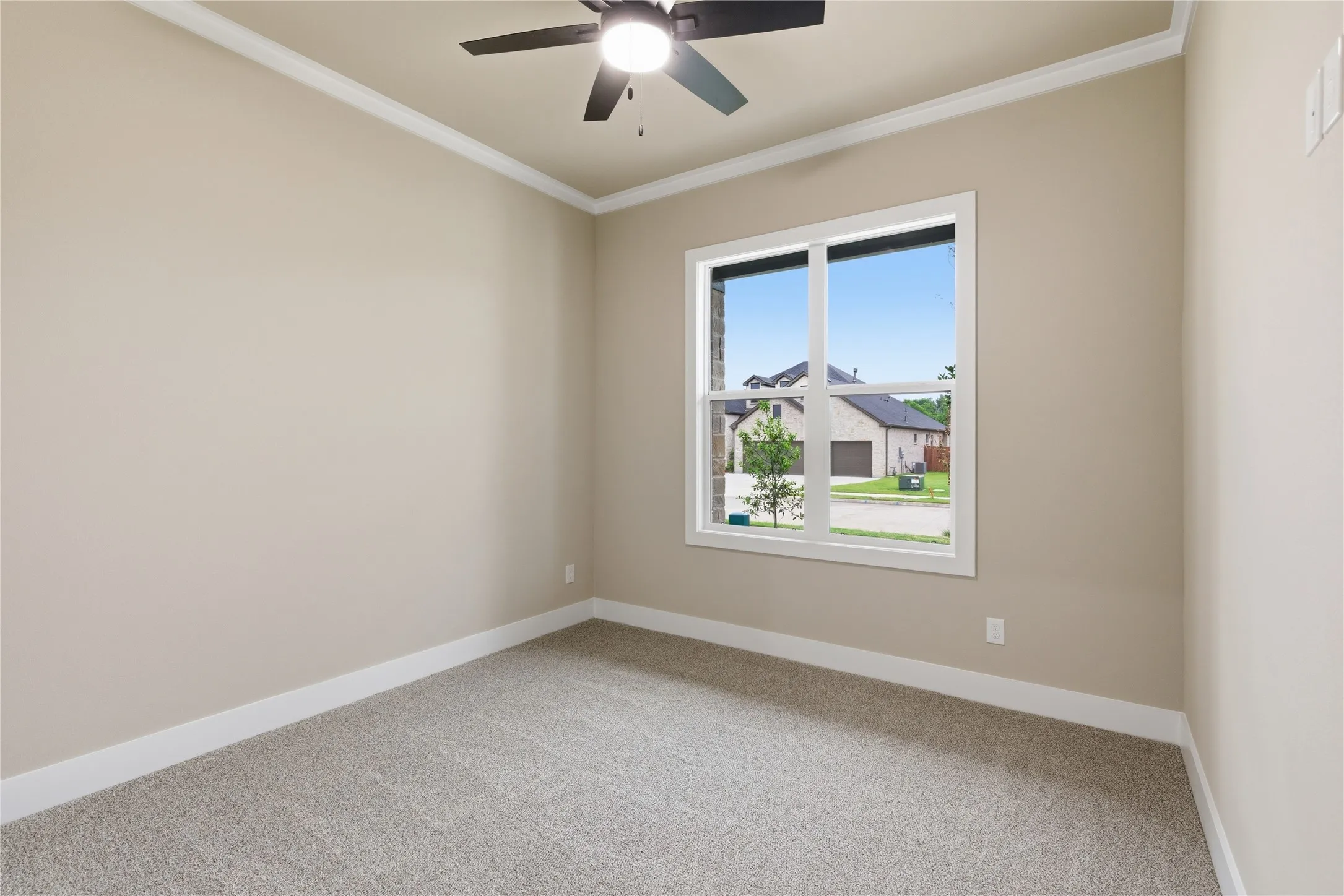 Neutral-toned room featuring a ceiling fan, crown molding, and light-colored carpeting