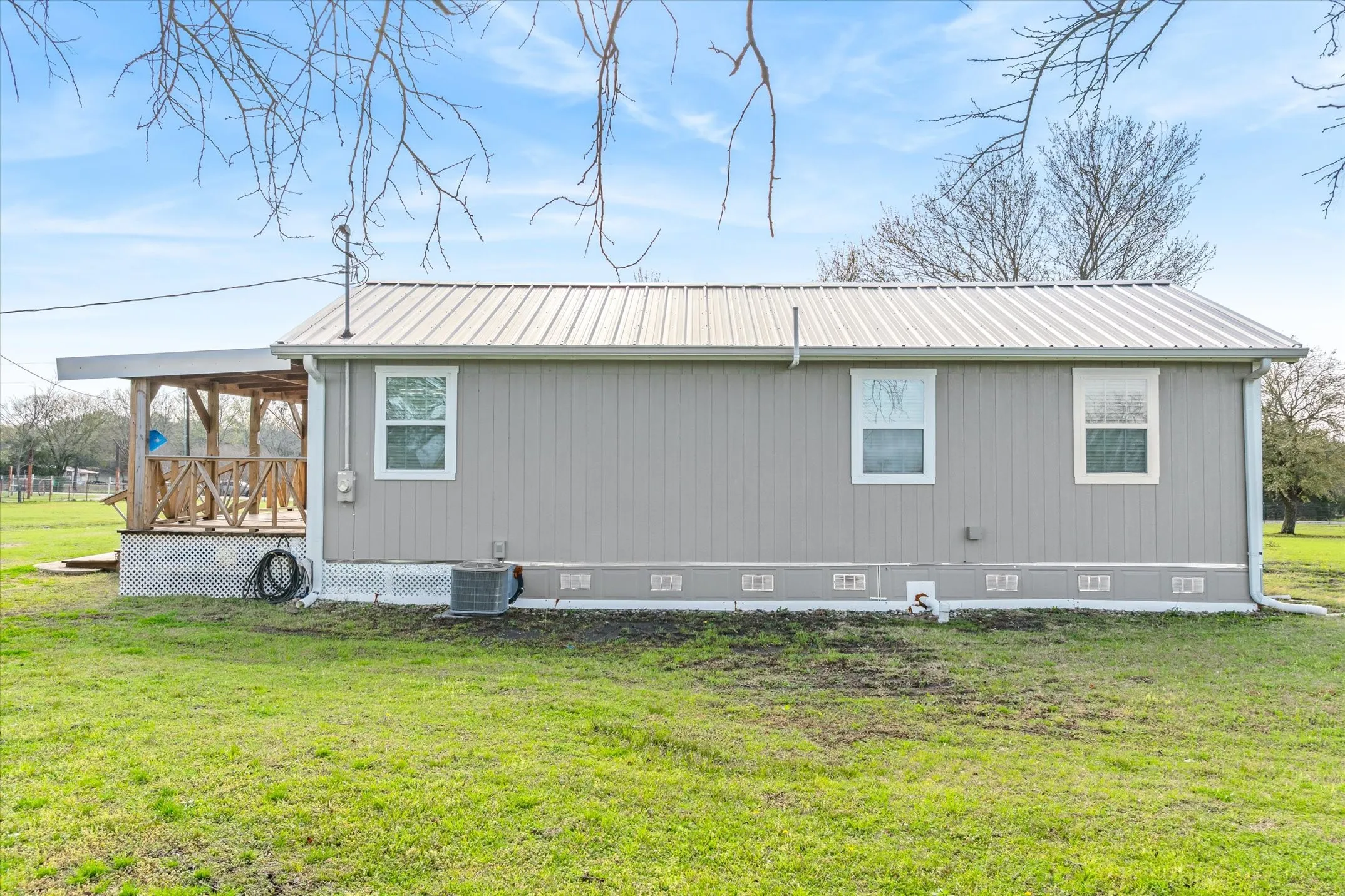 Backside of home featuring crawl space, a metal roof, a yard, and a wooden deck