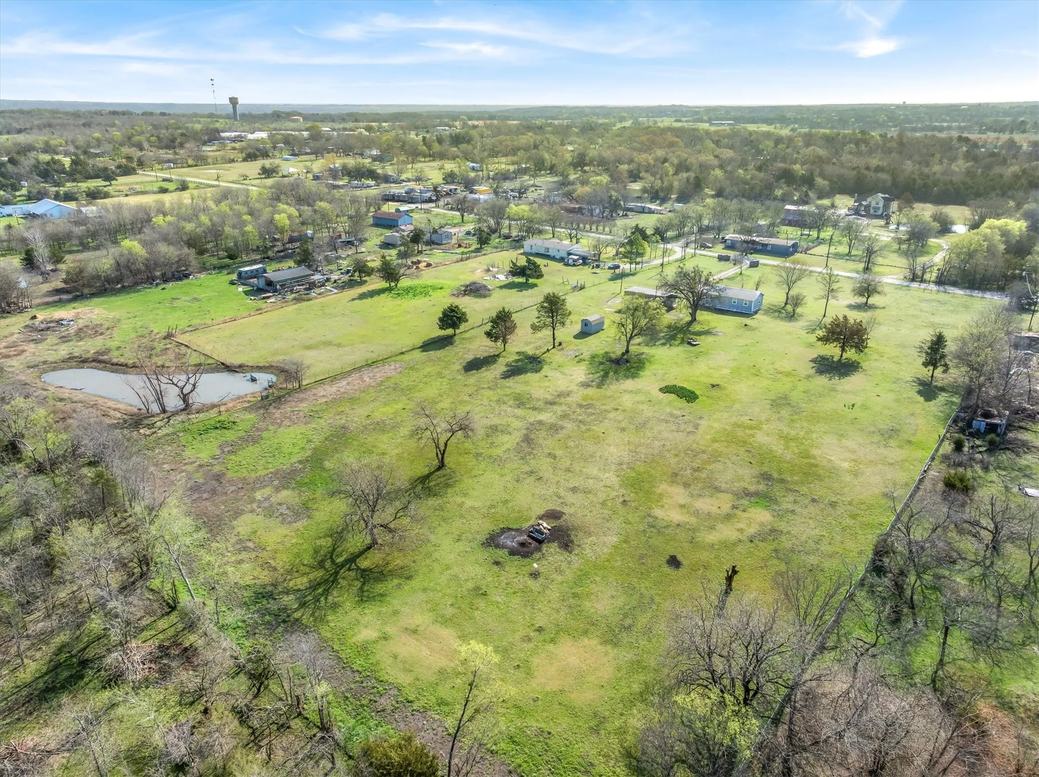 Drone / aerial view of a nearby body of water and a tree filled landscape