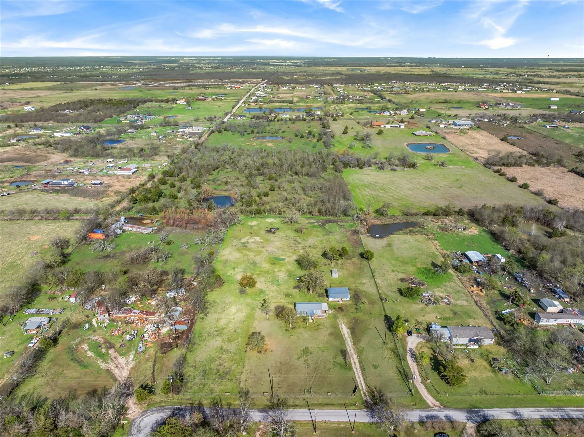 Aerial view of property and surrounding area featuring rural landscape and a large body of water