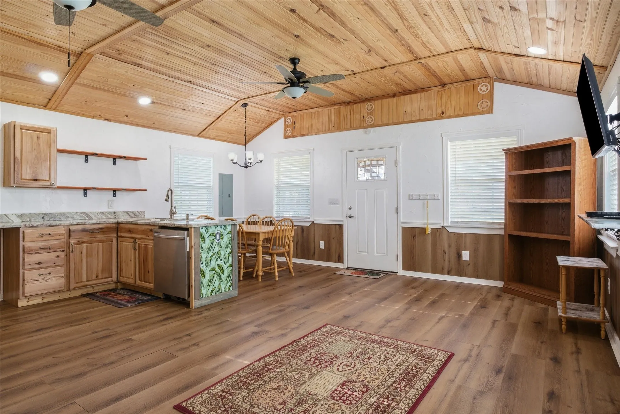 Kitchen featuring open shelves, ceiling fan, wainscoting, wooden ceiling, and dark wood-style flooring