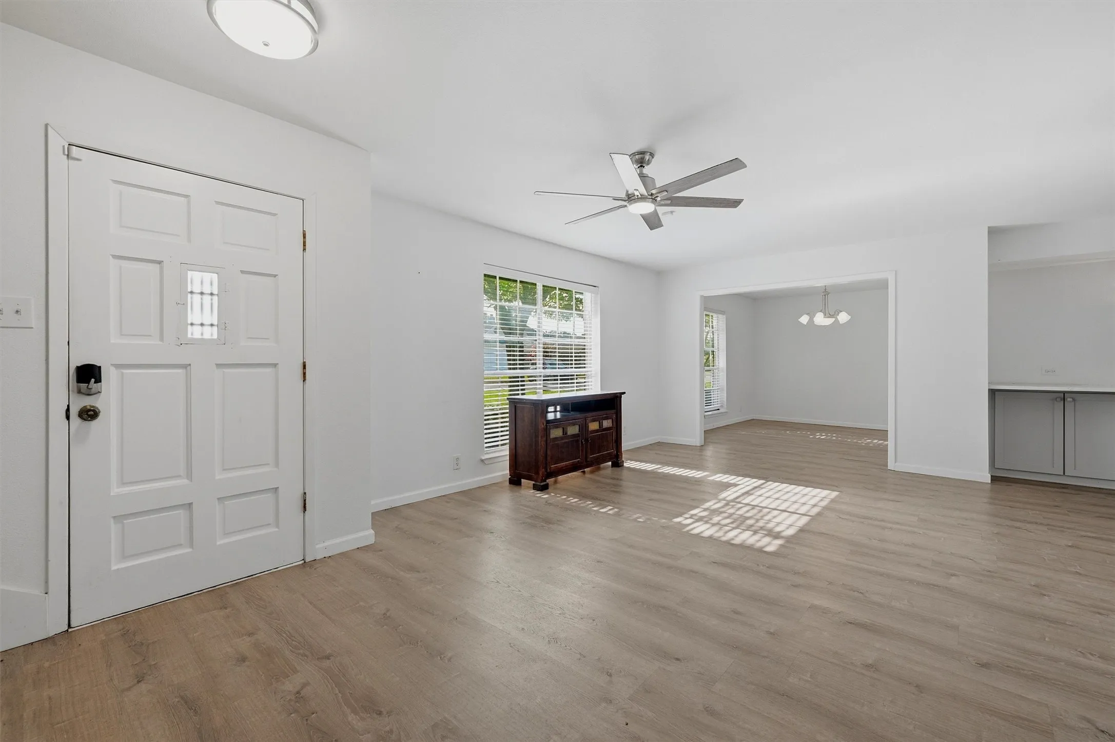 Light wood-finish flooring, recessed lighting, and a ceiling fan with integrated lighting