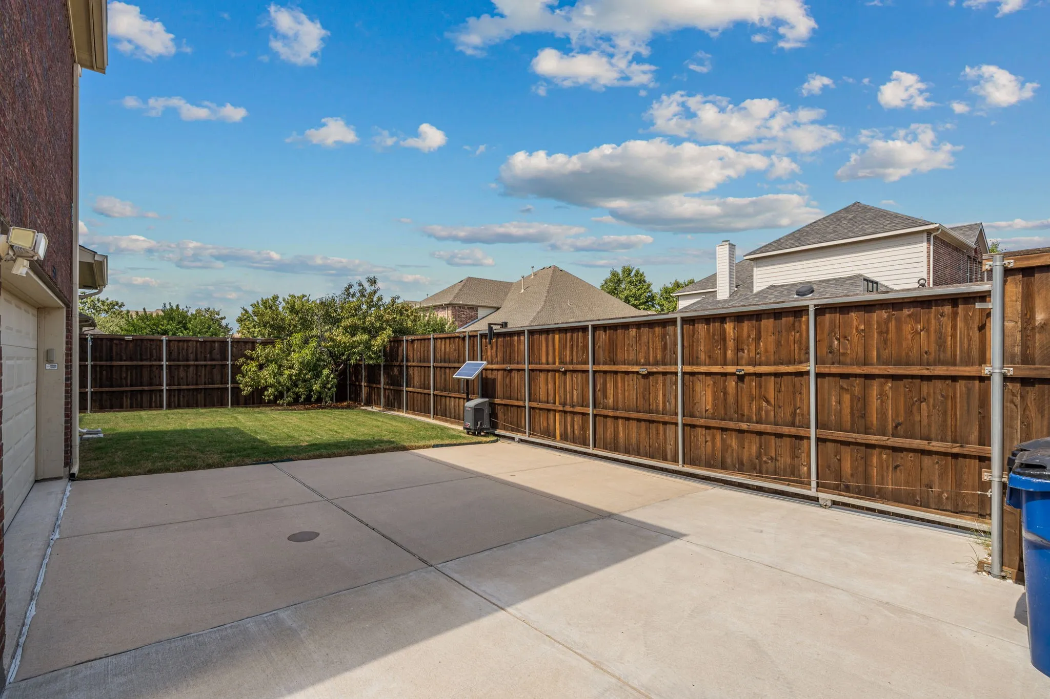 Fenced backyard with electric sliding gate