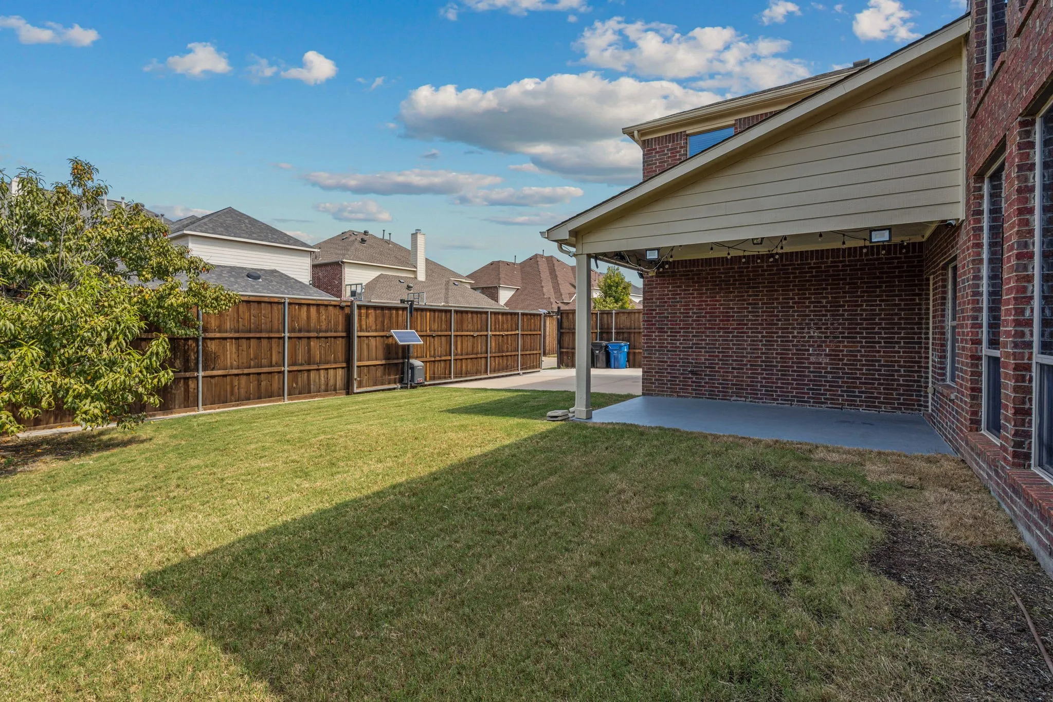 Fenced backyard with a patio area and the best peach tree