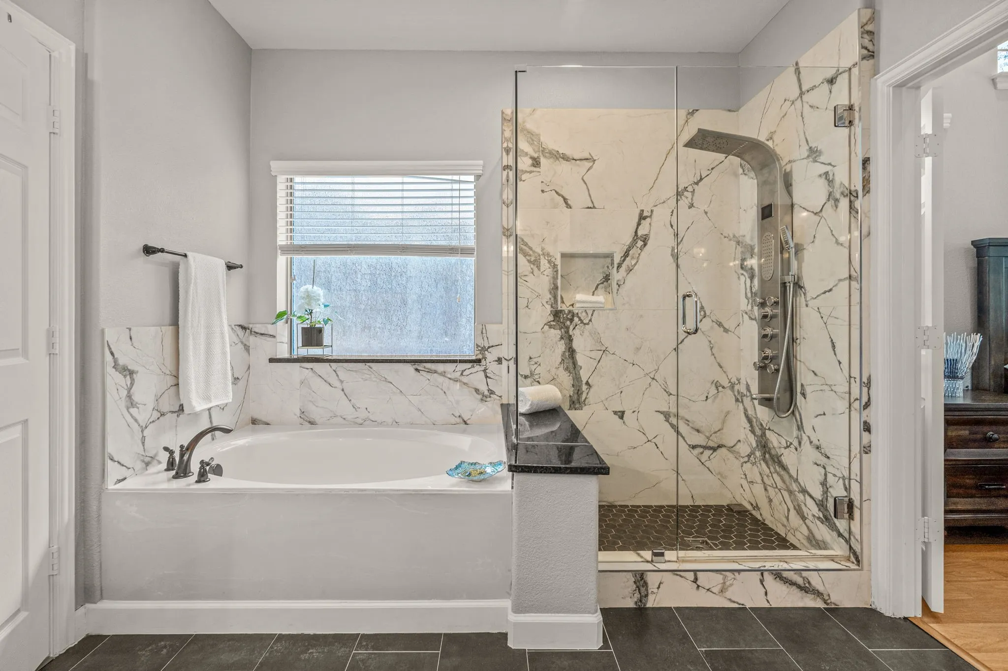 Bathroom featuring a marble finish shower and a garden tub