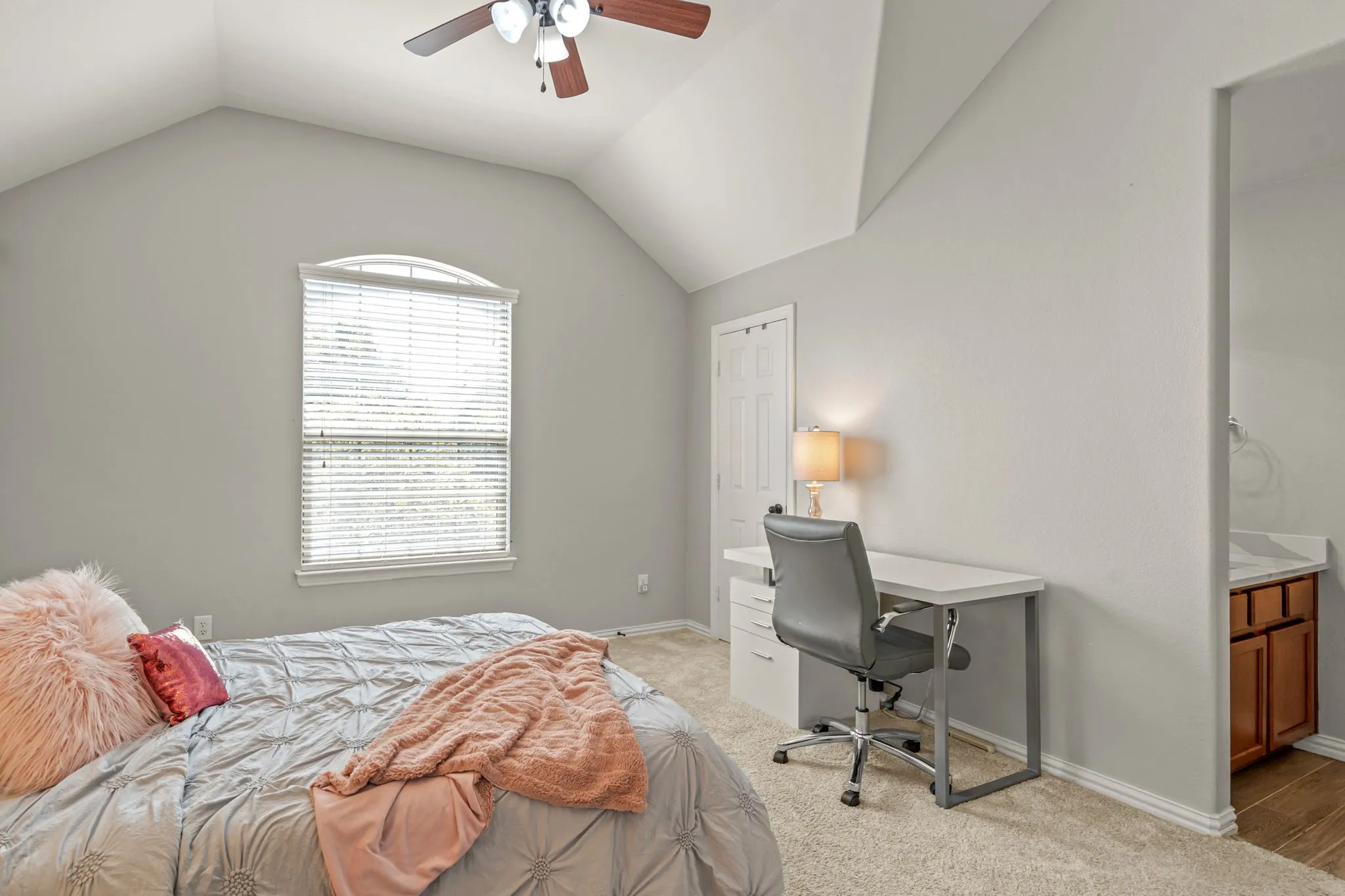 Bedroom featuring light colored carpet, a desk, ceiling fan, and ensuite bath