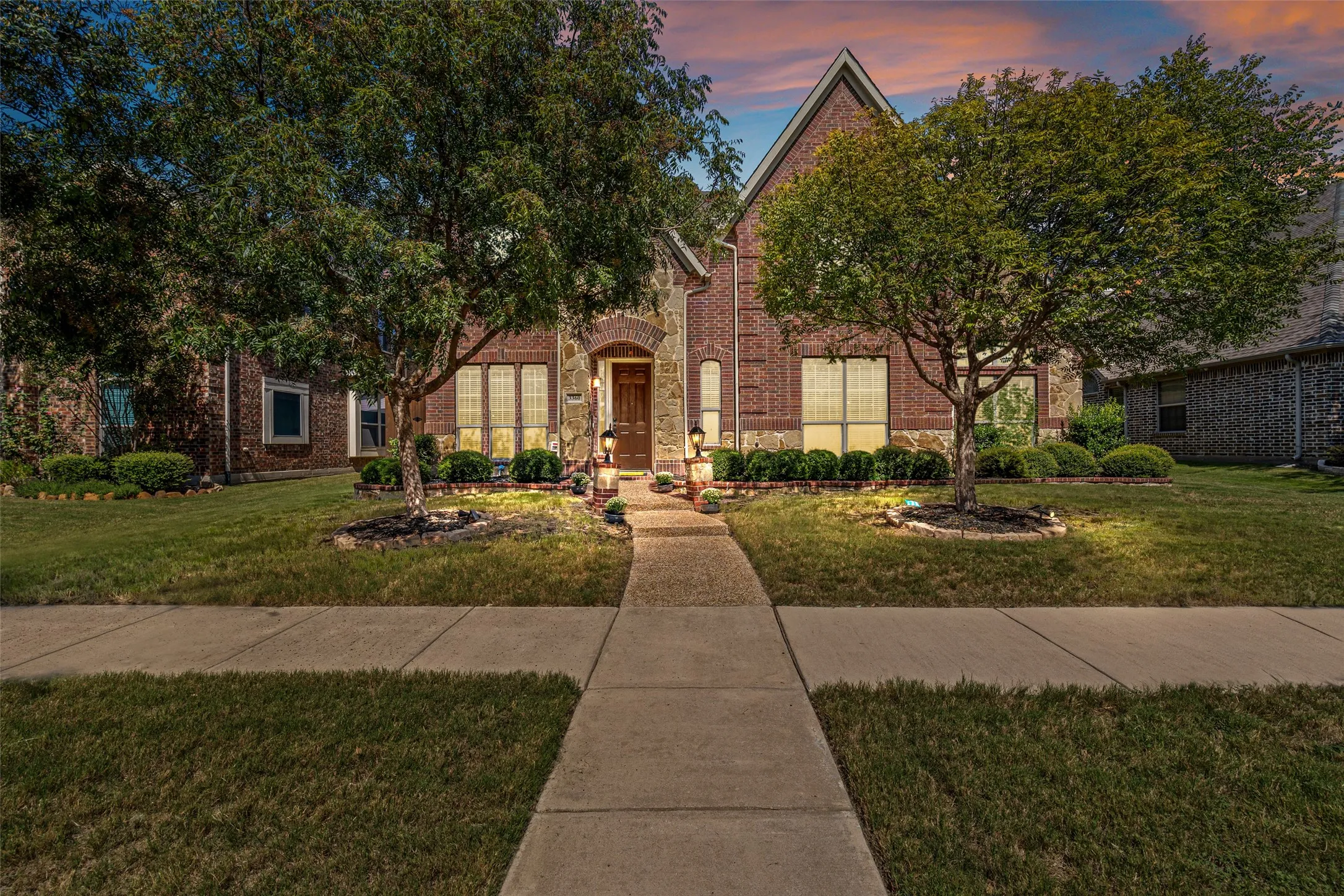 View of front facade featuring brick siding and a yard