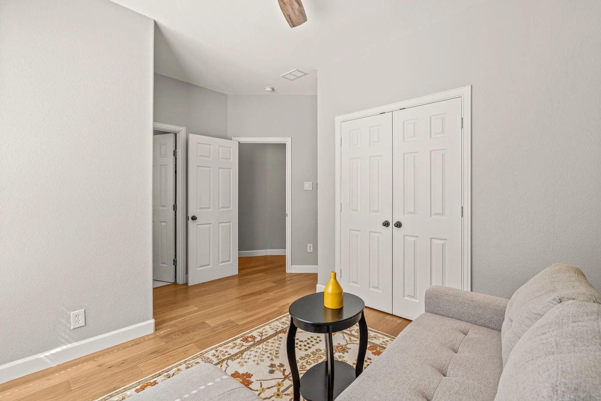 Light wood-style floors and a ceiling fan