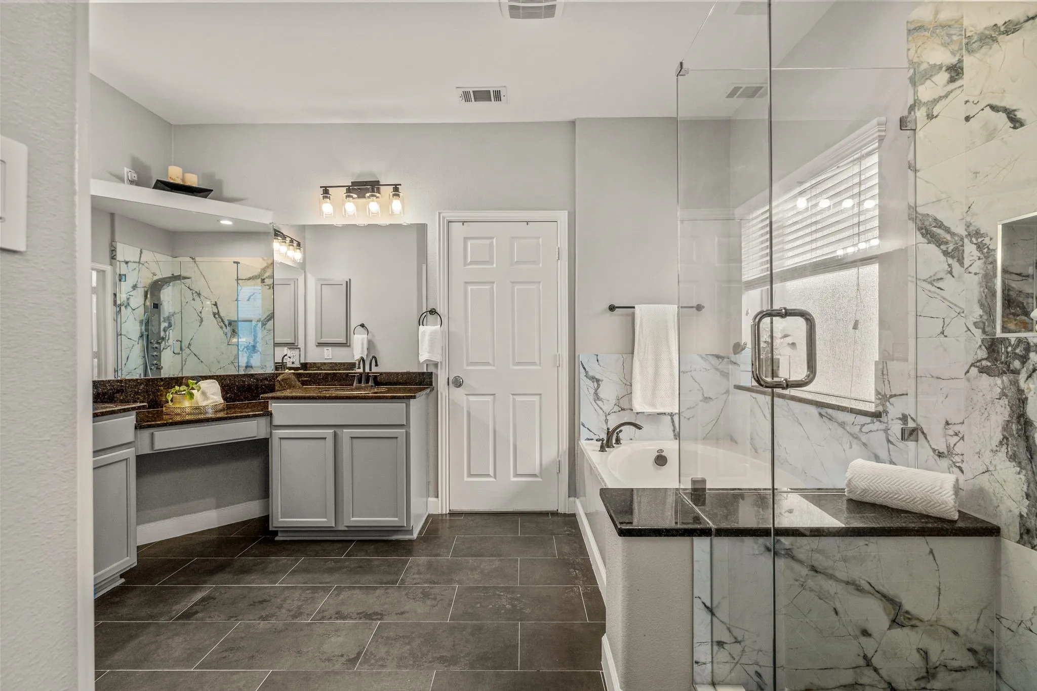 Full bath with vanity, a marble finish shower, and a garden tub