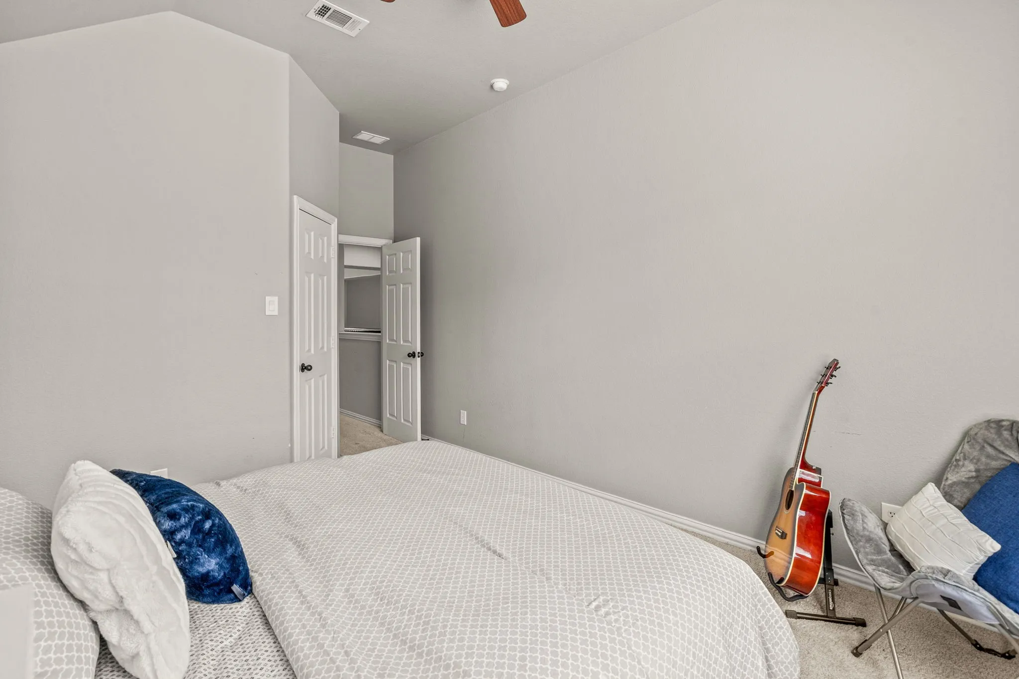 Bedroom with a ceiling fan and light carpet