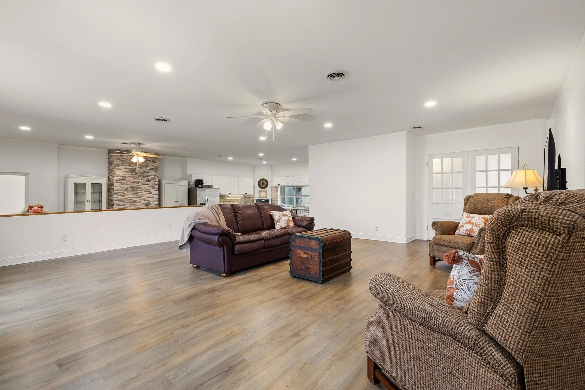 Living room with ceiling fan, light wood-style floors, and recessed lighting