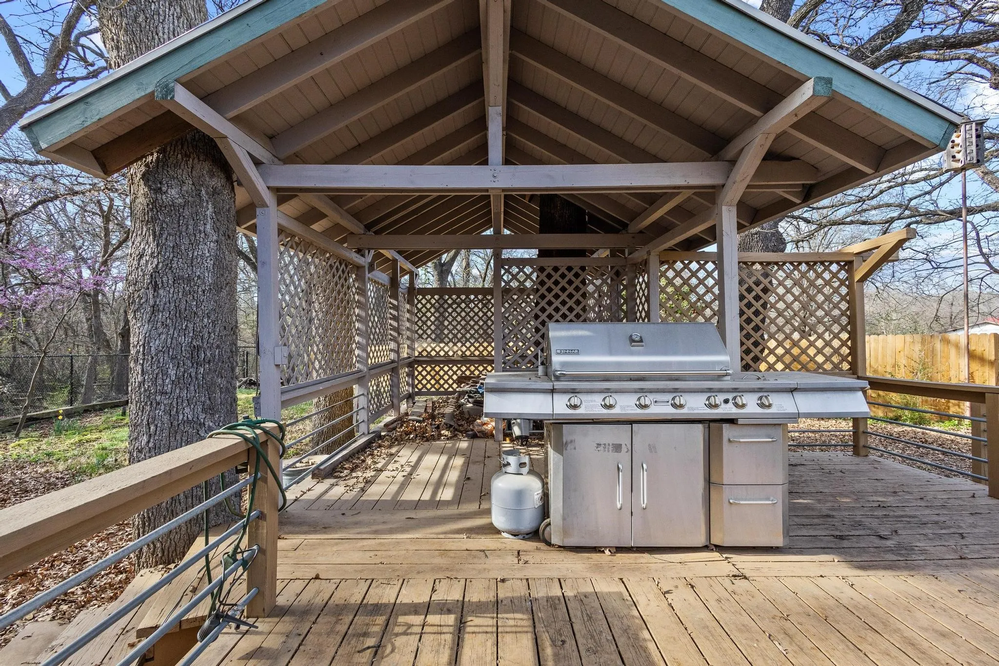 View of wooden terrace with grill and hot tub