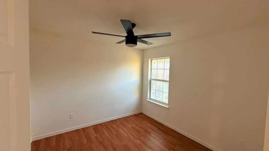 Unfurnished room with wood finished floors and ceiling fan