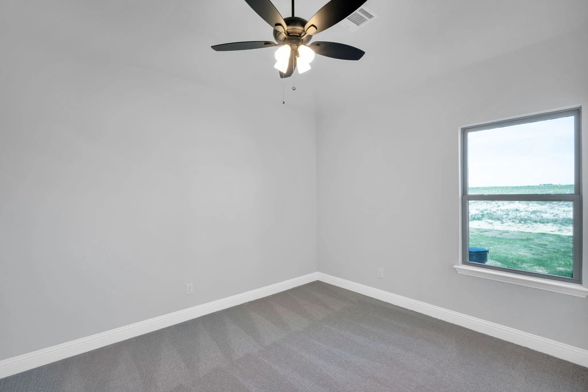 Spacious secondary room with natural light and neutral finishes.

