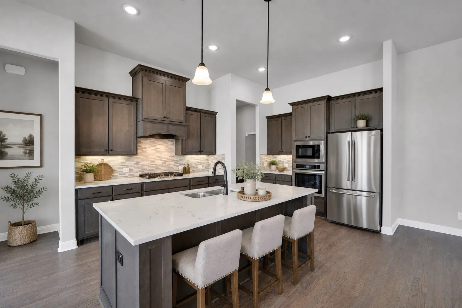 Designer kitchen featuring quartz countertops, oversized island, built-in oven and microwave, gas cooktop, and abundant cabinetry. Virtually staged