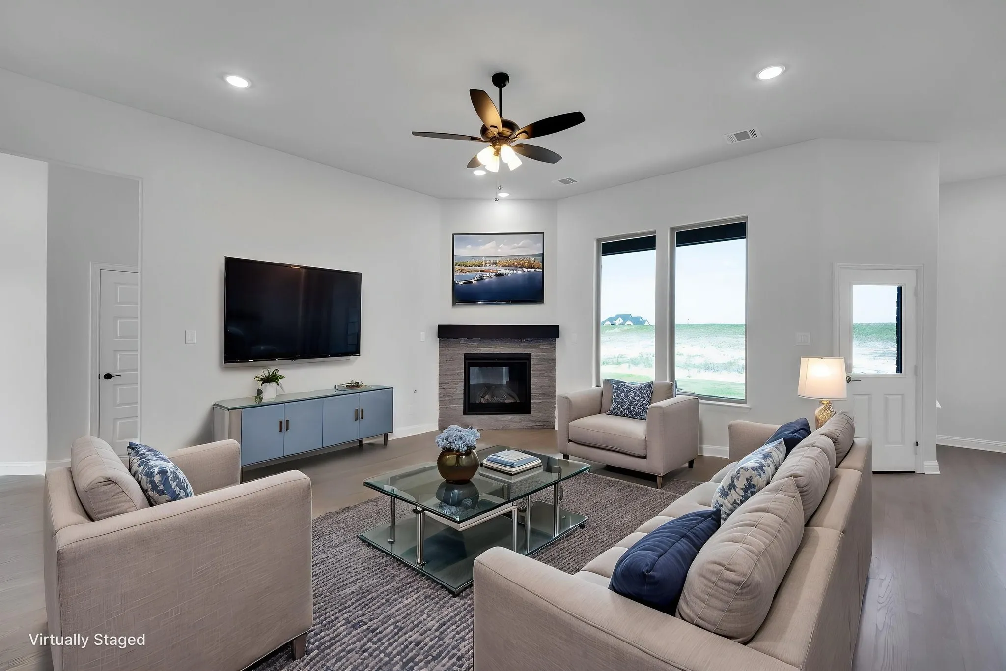 Spacious family room with fireplace, natural light, and seamless flow to the kitchen and dining area. Virtually staged.