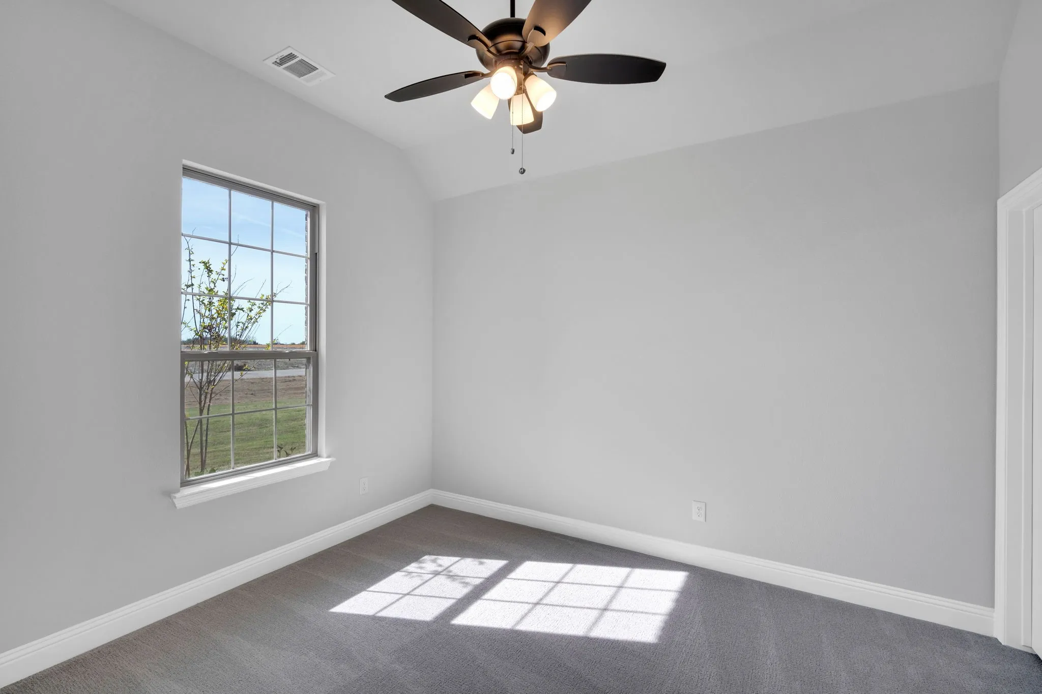 Spacious secondary room with natural light and neutral finishes.

