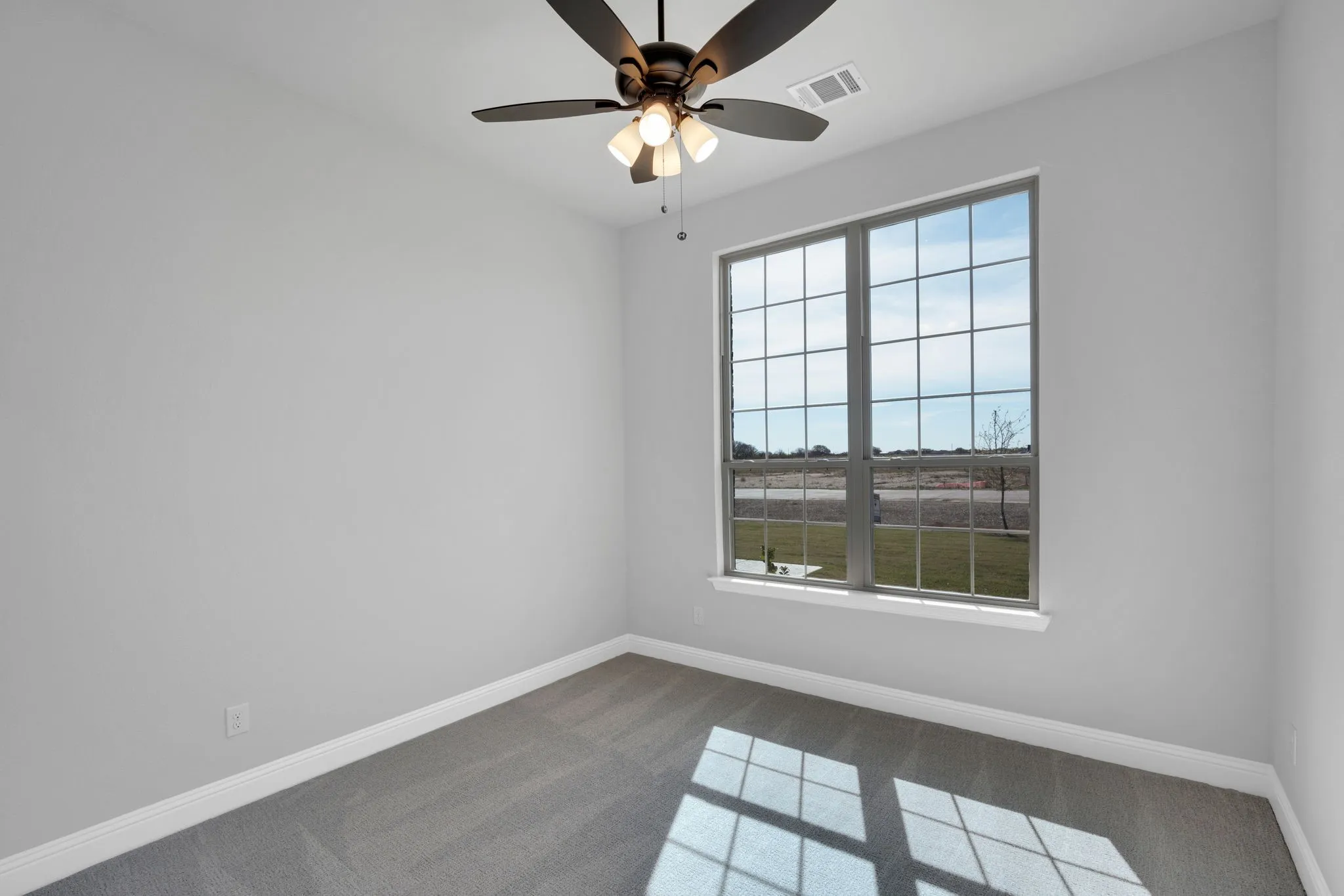 Spacious secondary room with natural light and neutral finishes.
