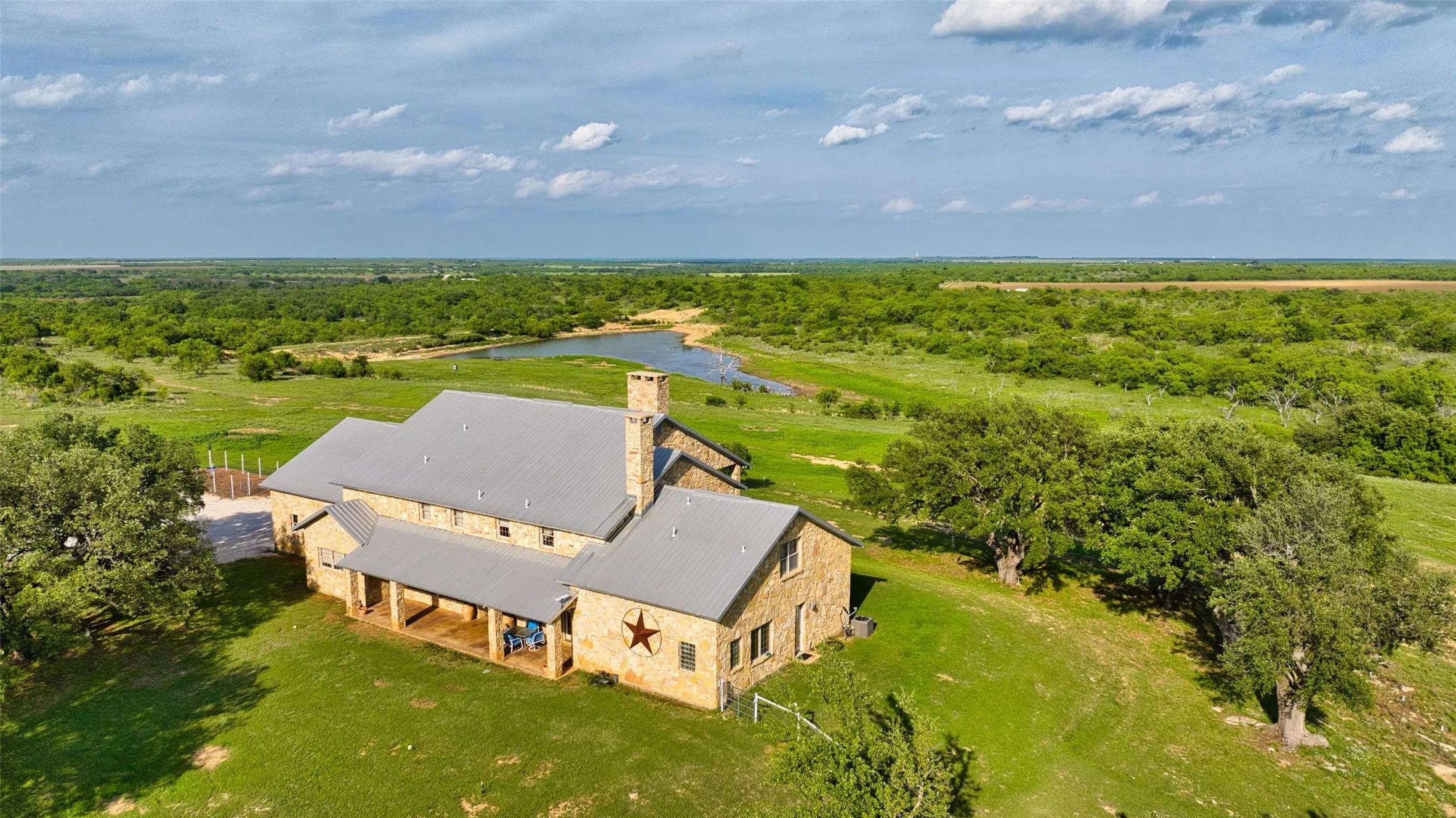 Stone exterior residence with a metal roof and a prominent chimney