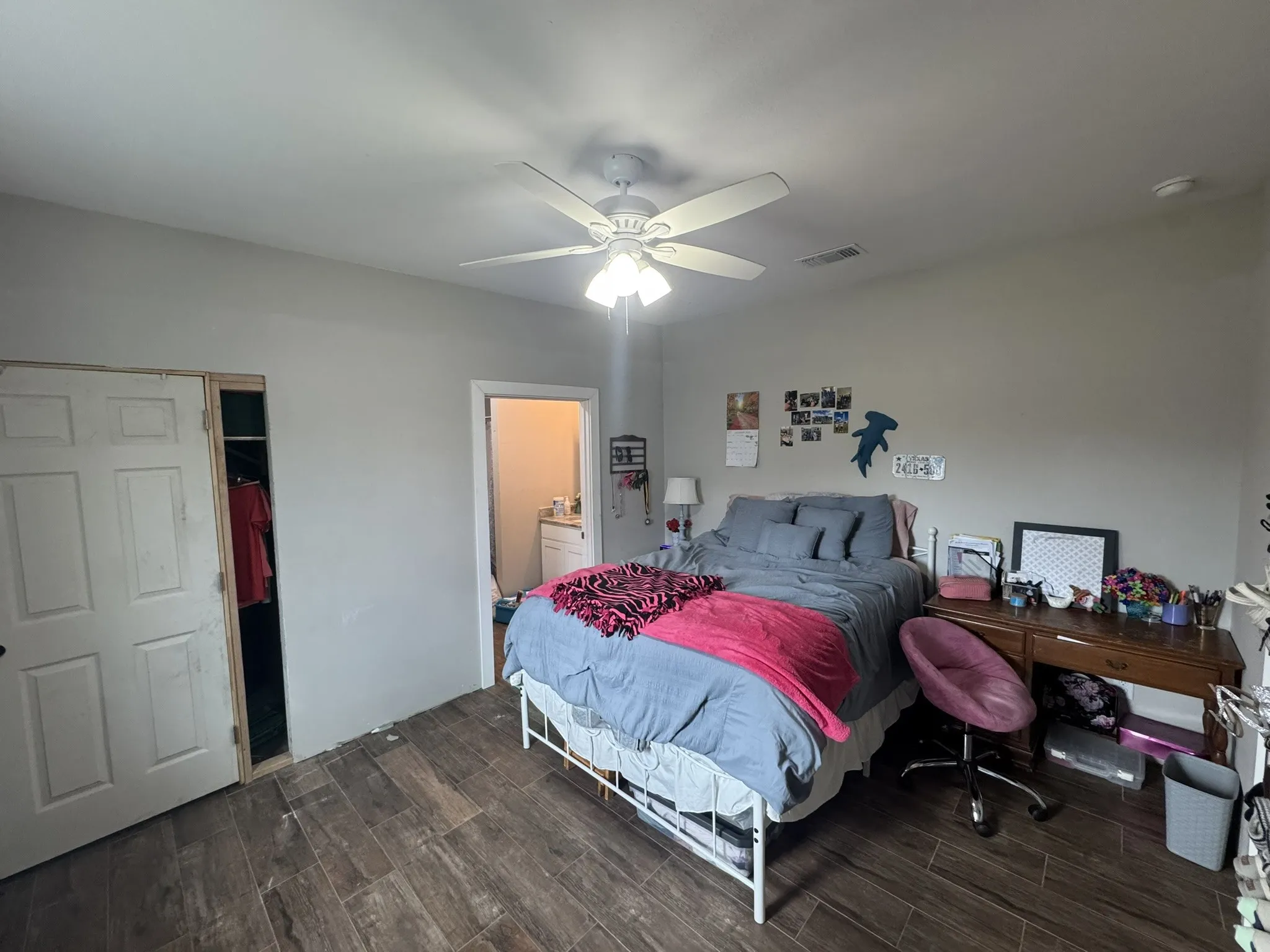 Bedroom with wood finish floors, a ceiling fan, and a spacious closet
