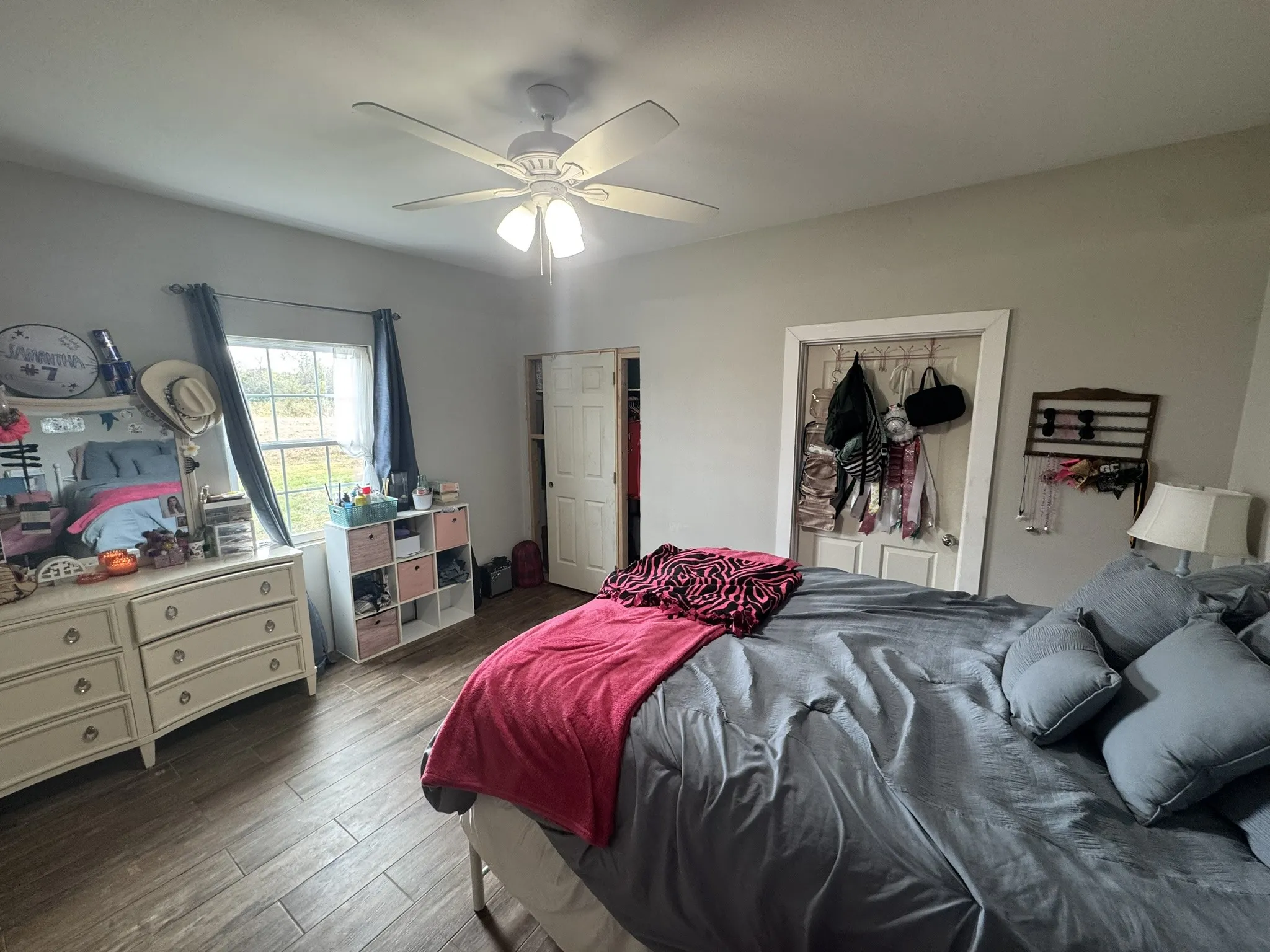 Bedroom with wood finished floors, a ceiling fan, and a closet