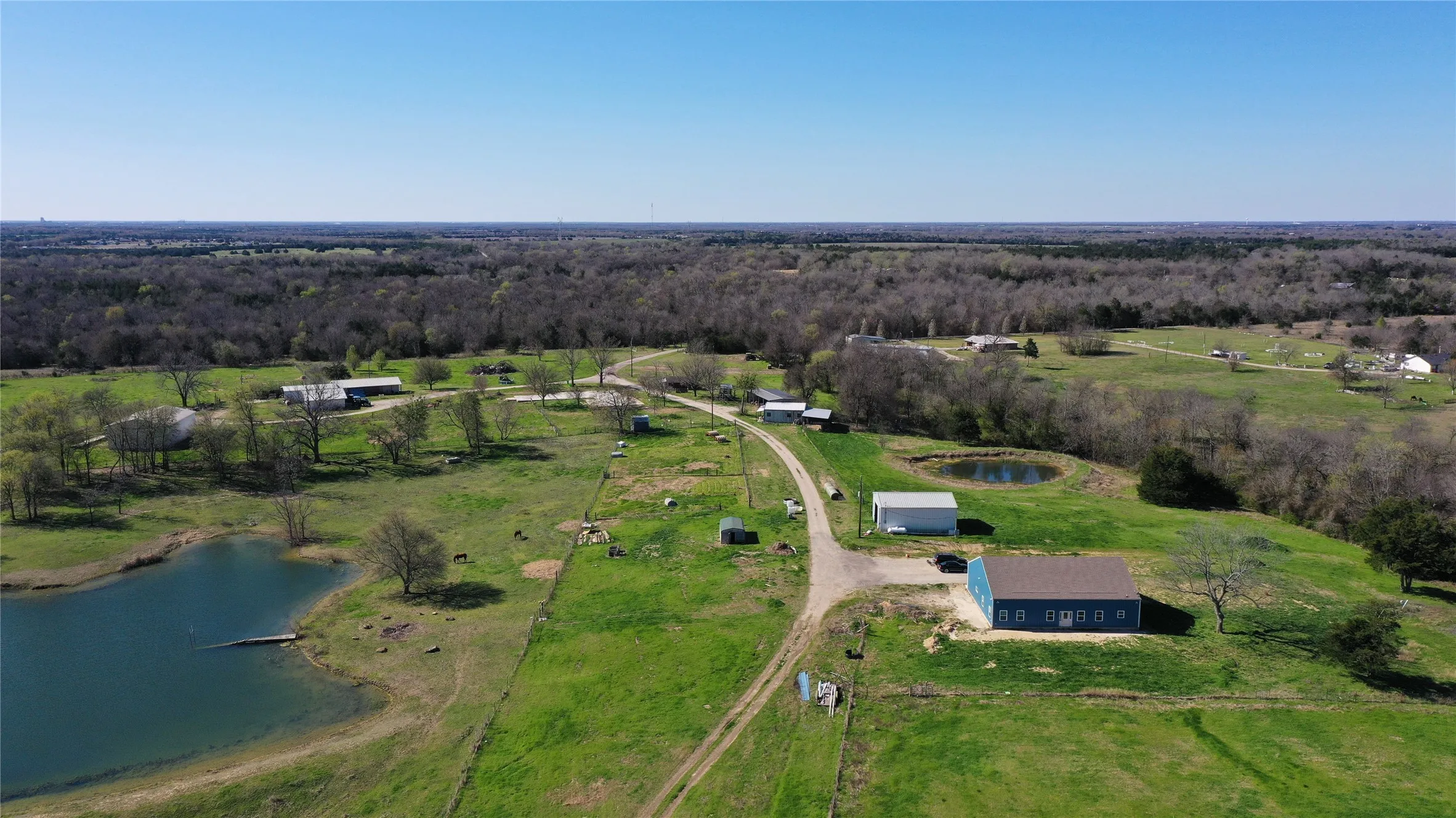 Drone / aerial view featuring a wooded view, a water view, and a rural view