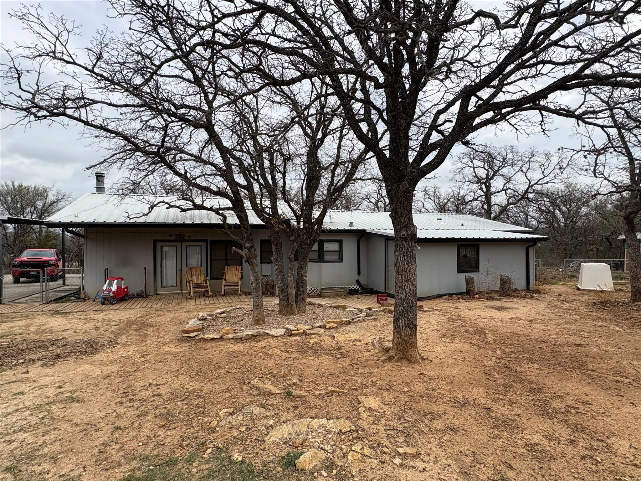 Rear view of house featuring a patio and a metal roof, water well
