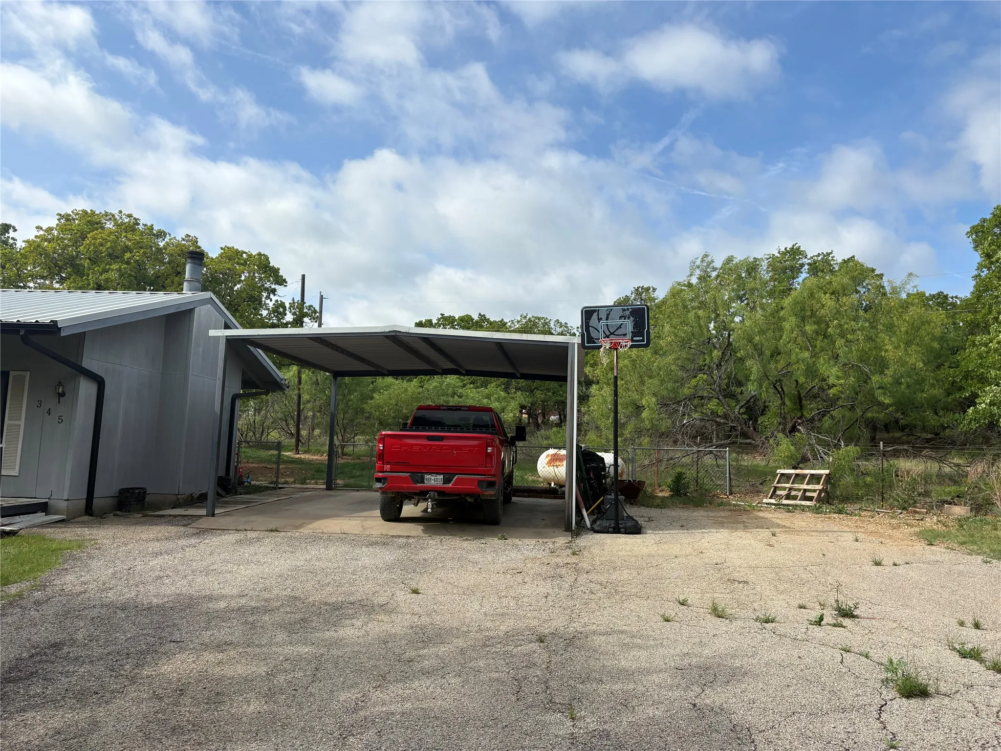 The property features a carport and a gravel driveway