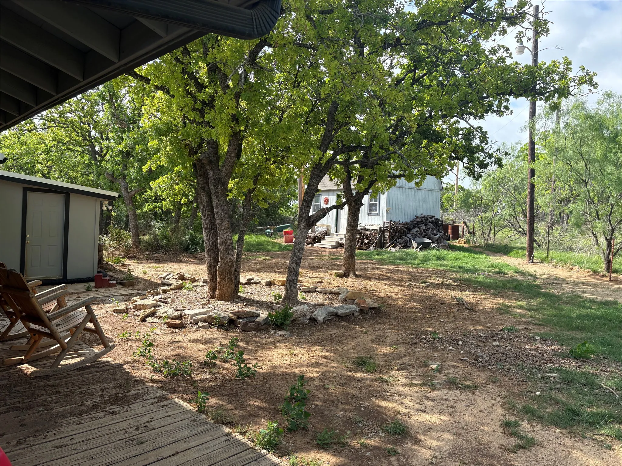 The property features an expansive outdoor area with mature trees and a detached shed