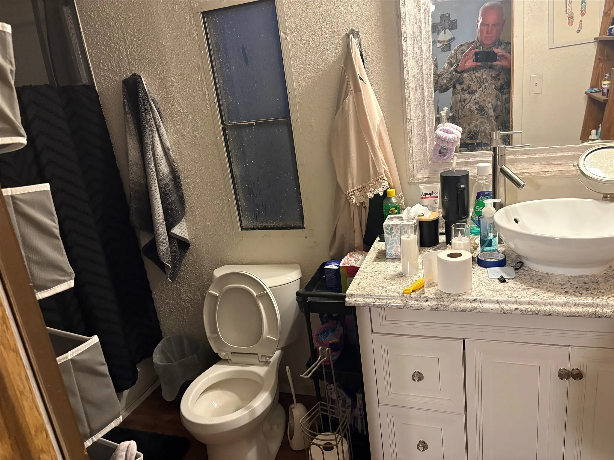 Bathroom with a textured wall and vanity