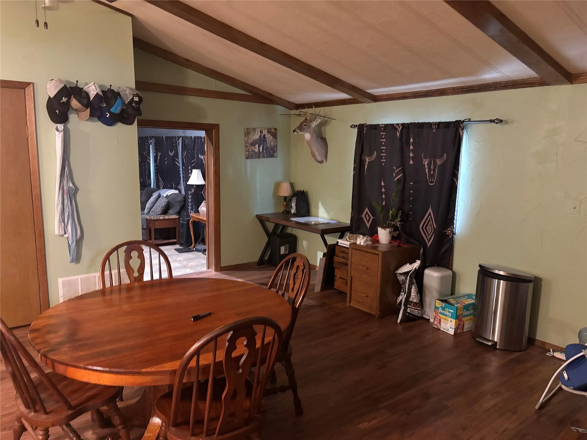 This room features a vaulted ceiling with visible beams and wood-style flooring