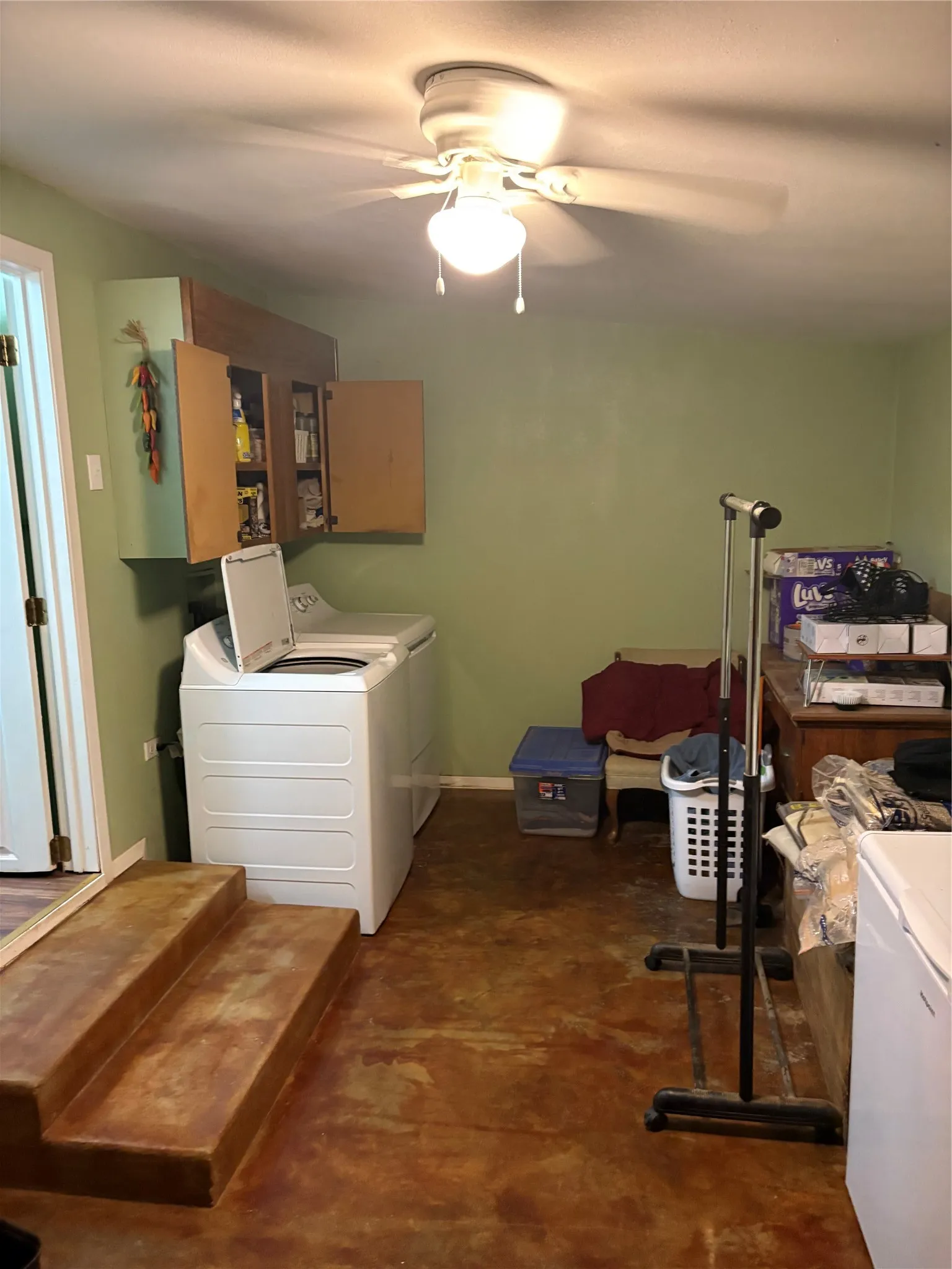 Laundry room with cabinet space, washing machine and clothes dryer, and a ceiling fan