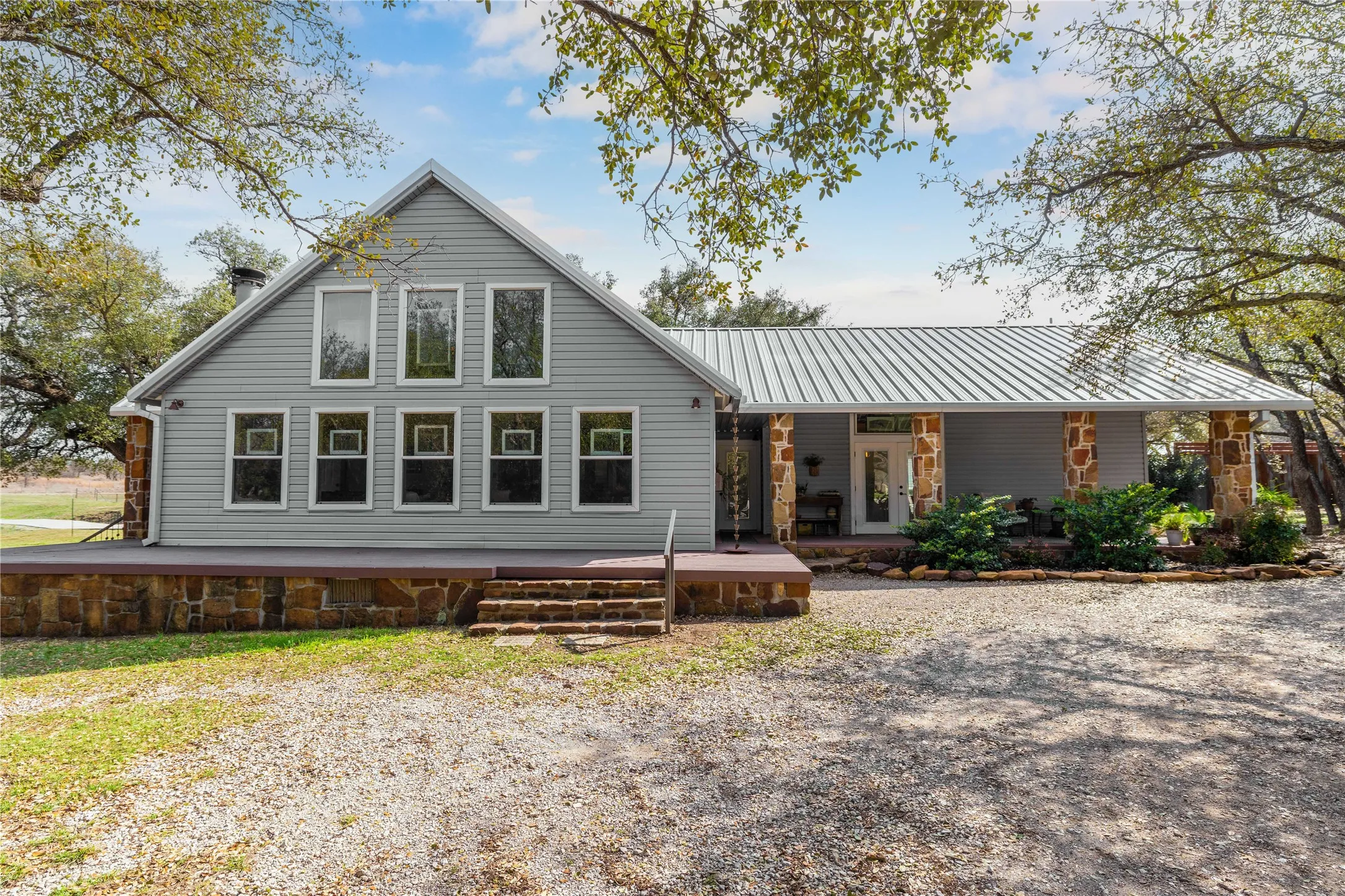 Back of property with covered porch and a standing seam roof