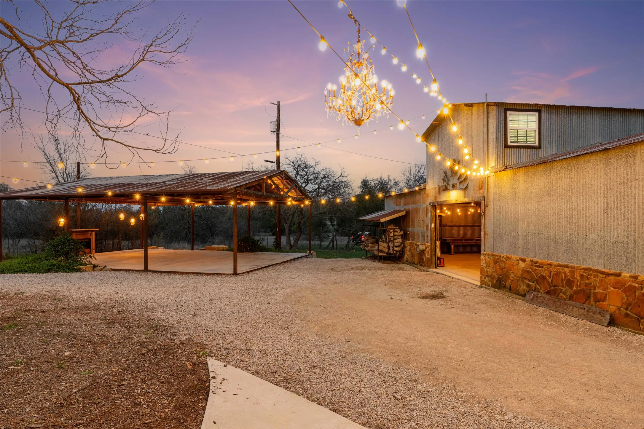 Yard at dusk with a patio, a carport, and gravel driveway
