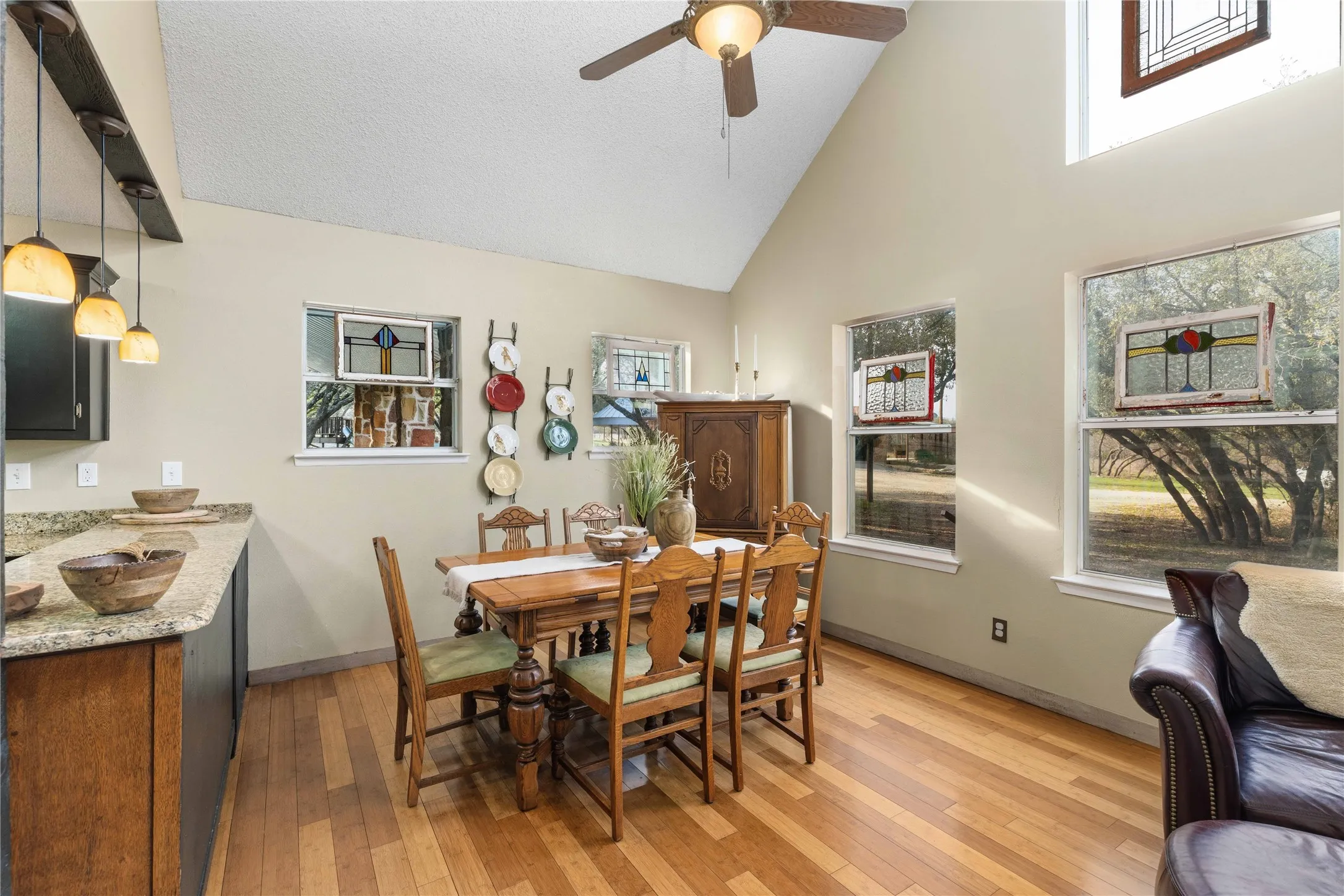 Dining room featuring light wood-type flooring, plenty of natural light, ceiling fan, and vaulted ceiling