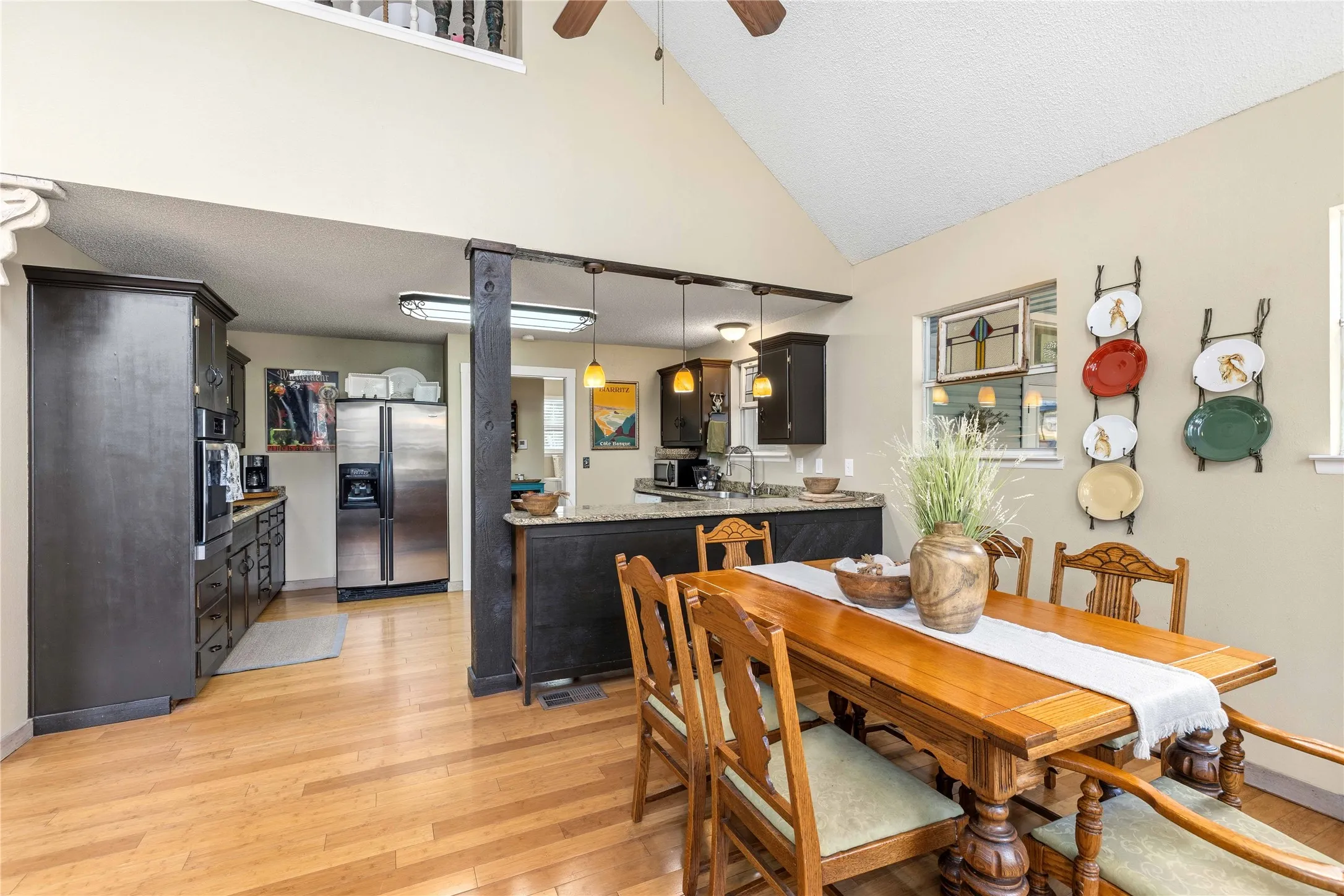 Dining area with light wood-type flooring, ceiling fan, and lofted ceiling