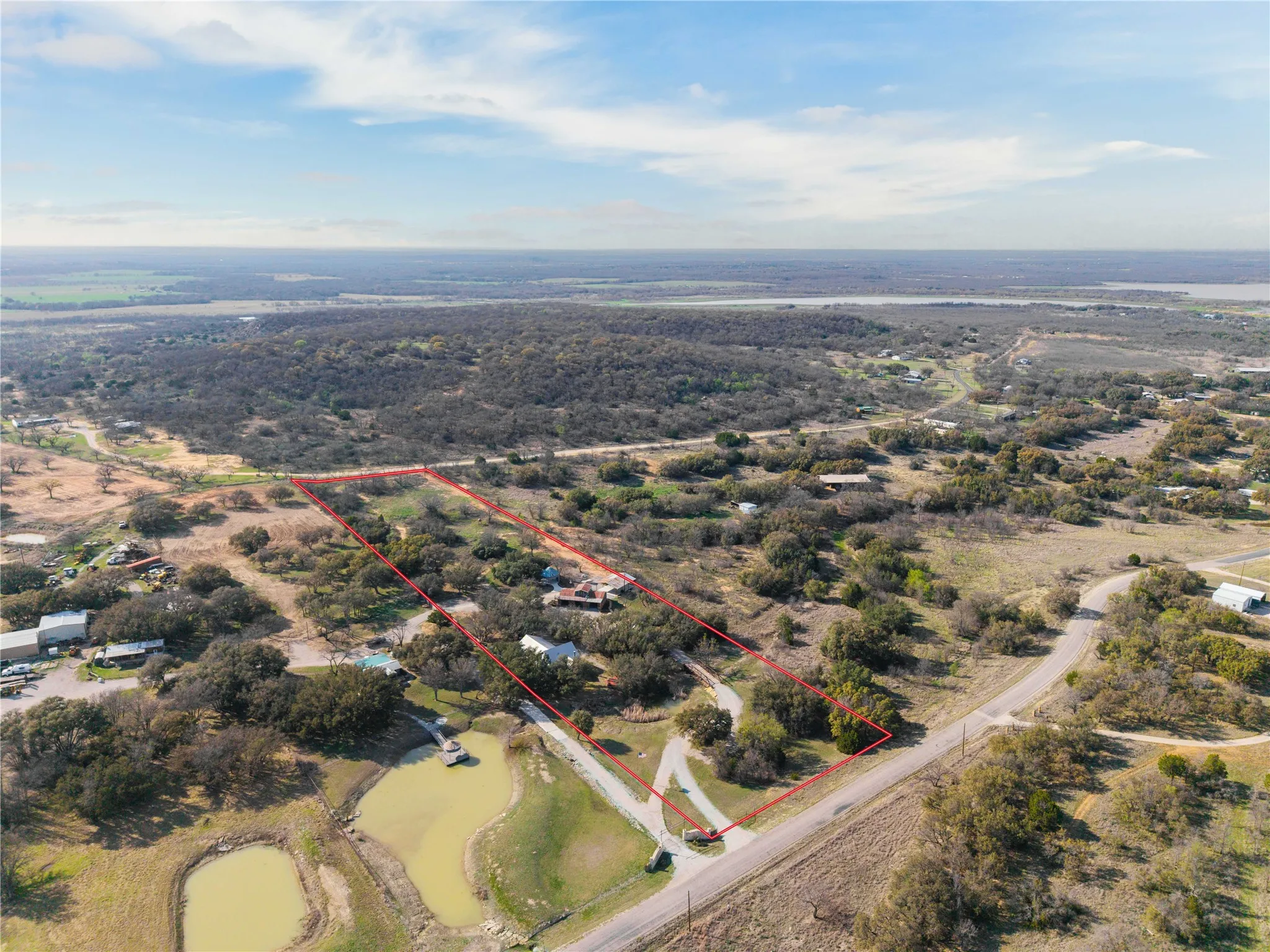 Aerial view of sparsely populated area with property parcel outlined