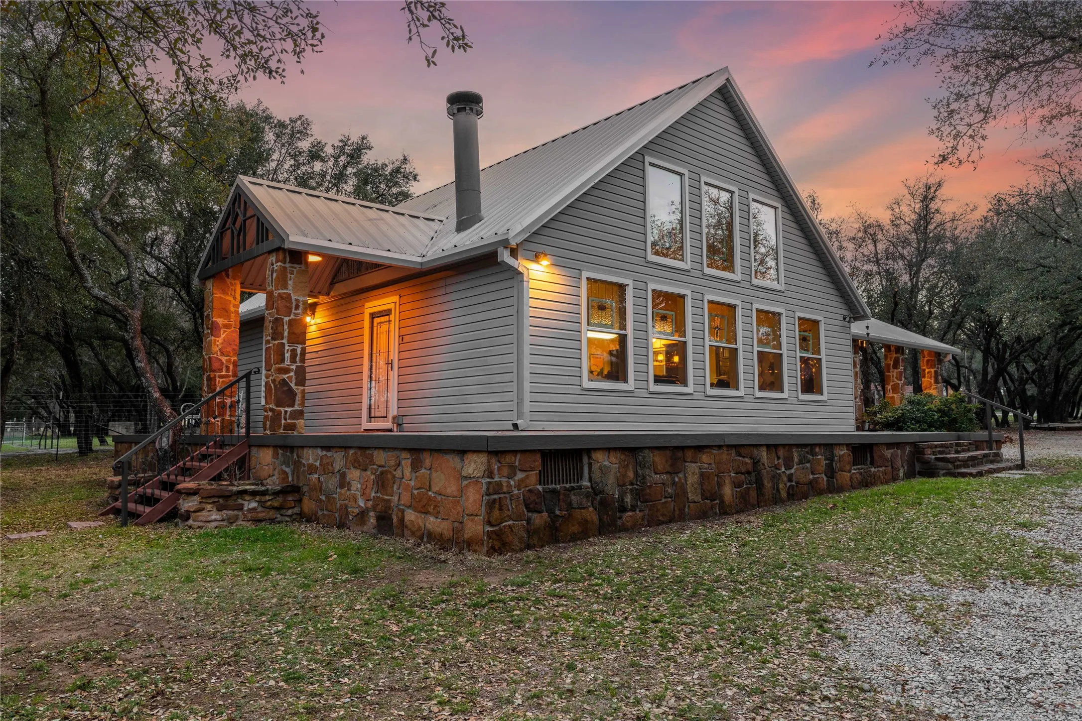 View of side of home with a metal roof, a yard, covered porch, and a chimney