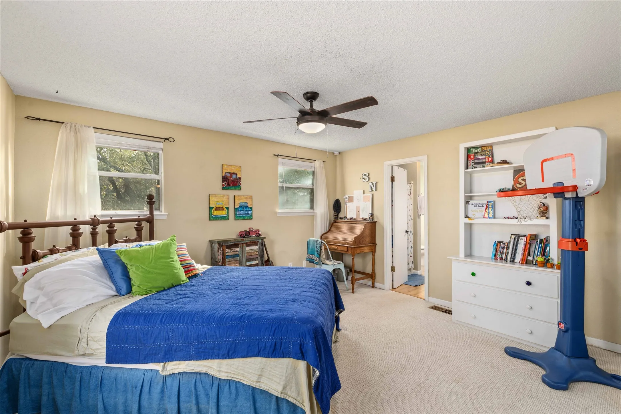 Carpeted bedroom featuring ceiling fan and a textured ceiling