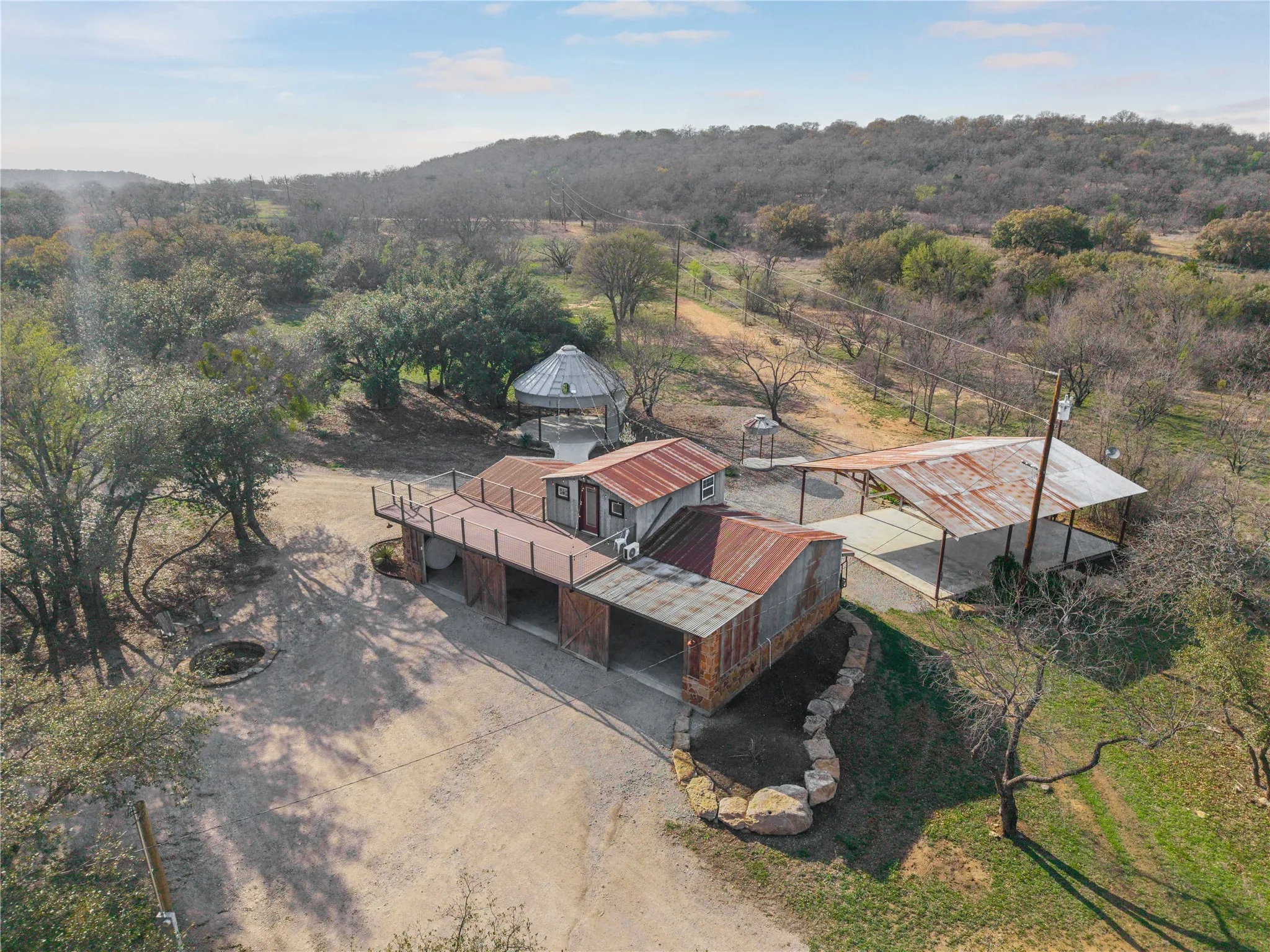 Aerial view of property and surrounding area featuring a heavily wooded area