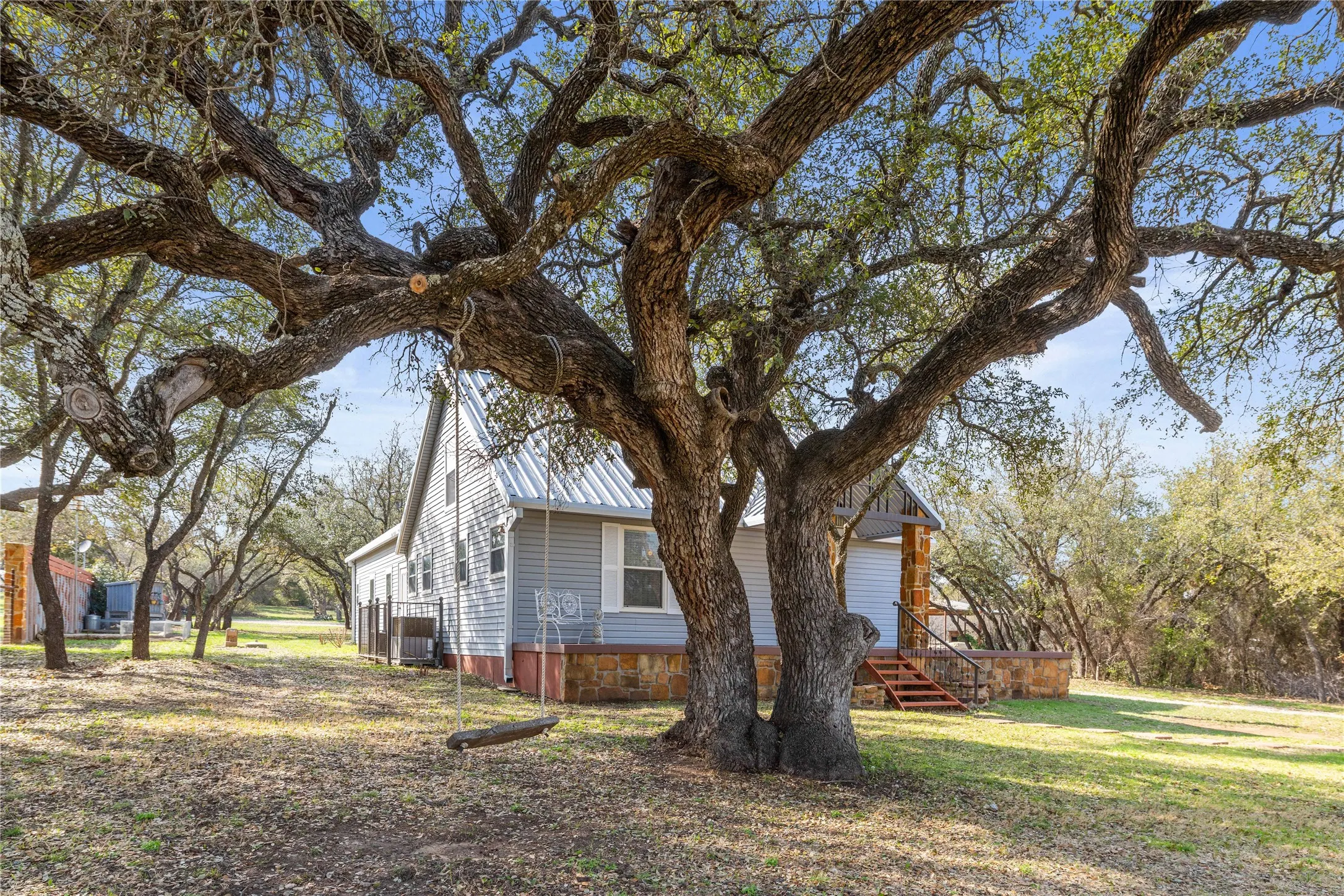 View of side of home with a metal roof and a lawn