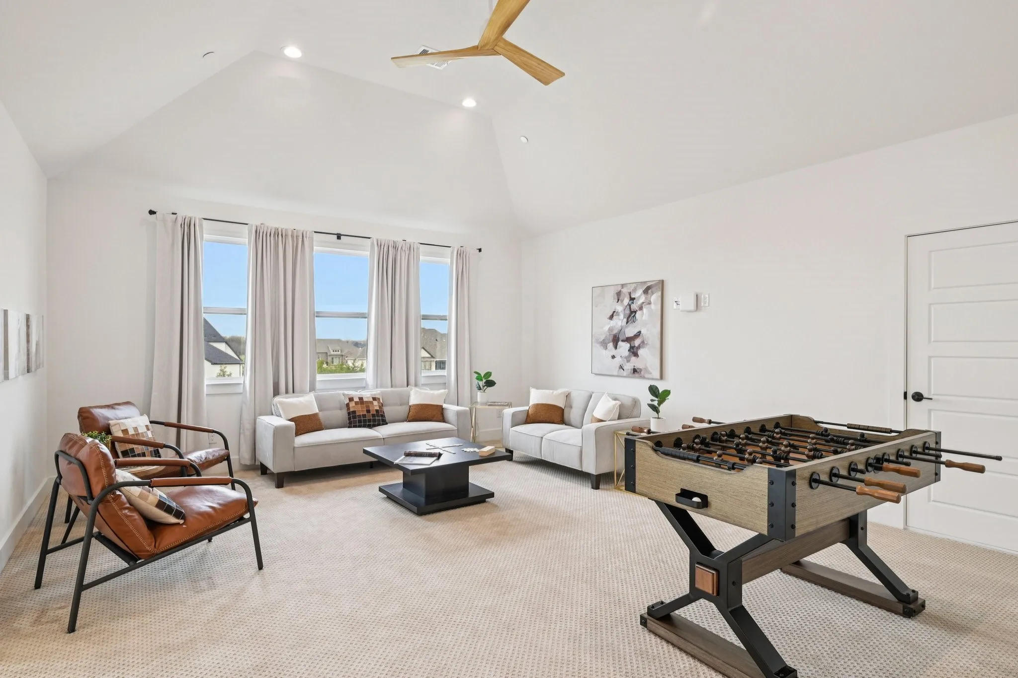 Large and bright game room with vaulted ceilings and large storage closet.