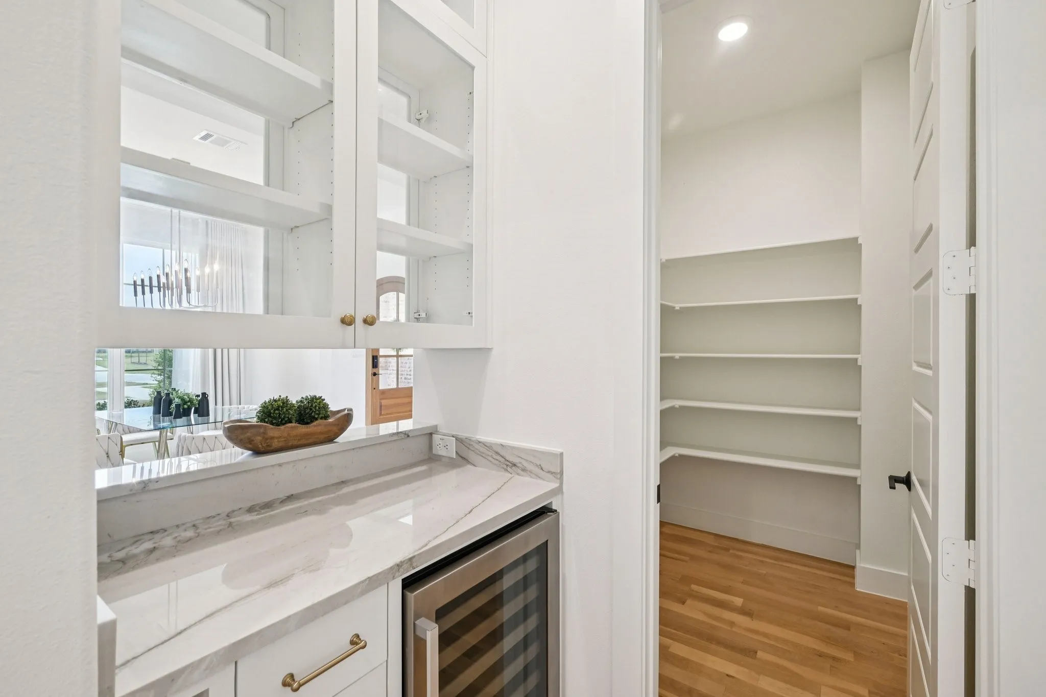 Dry bar with wine refrigerator and leads into huge walk-in pantry