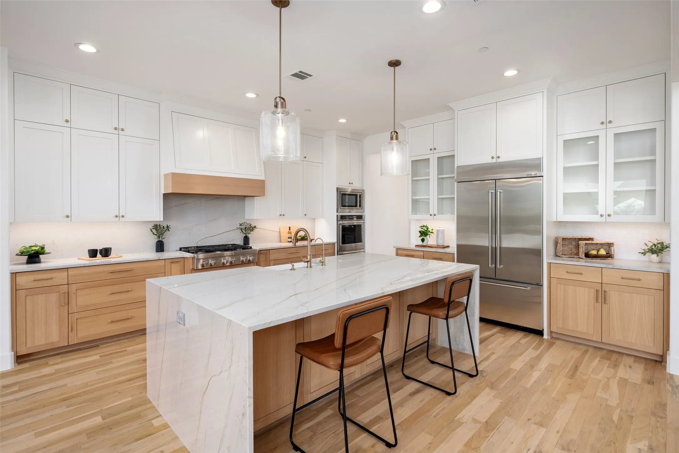 Gorgeous two tone cabinetry with huge waterfall quartz island