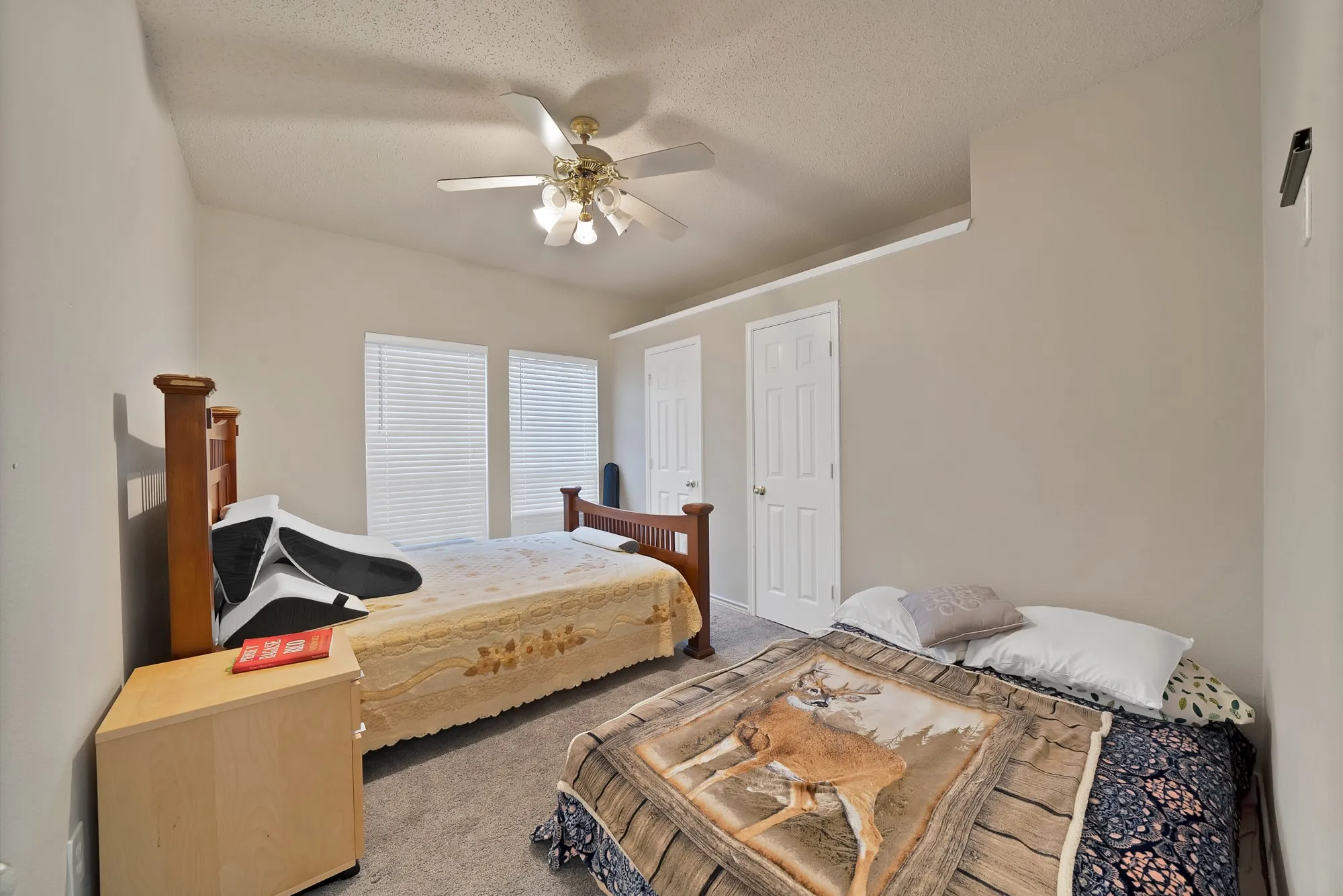 Bedroom featuring carpet floors, a textured ceiling, and a ceiling fan