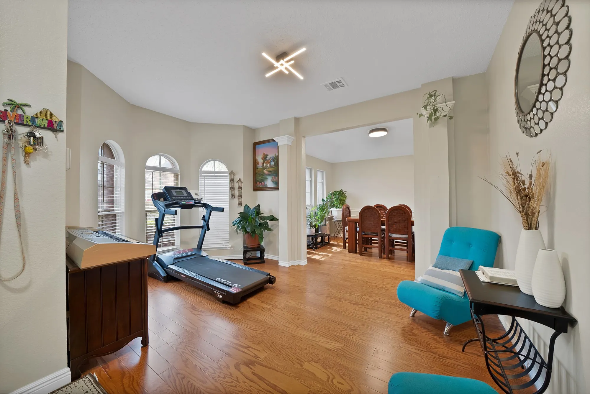 Exercise area featuring wood finished floors and decorative columns