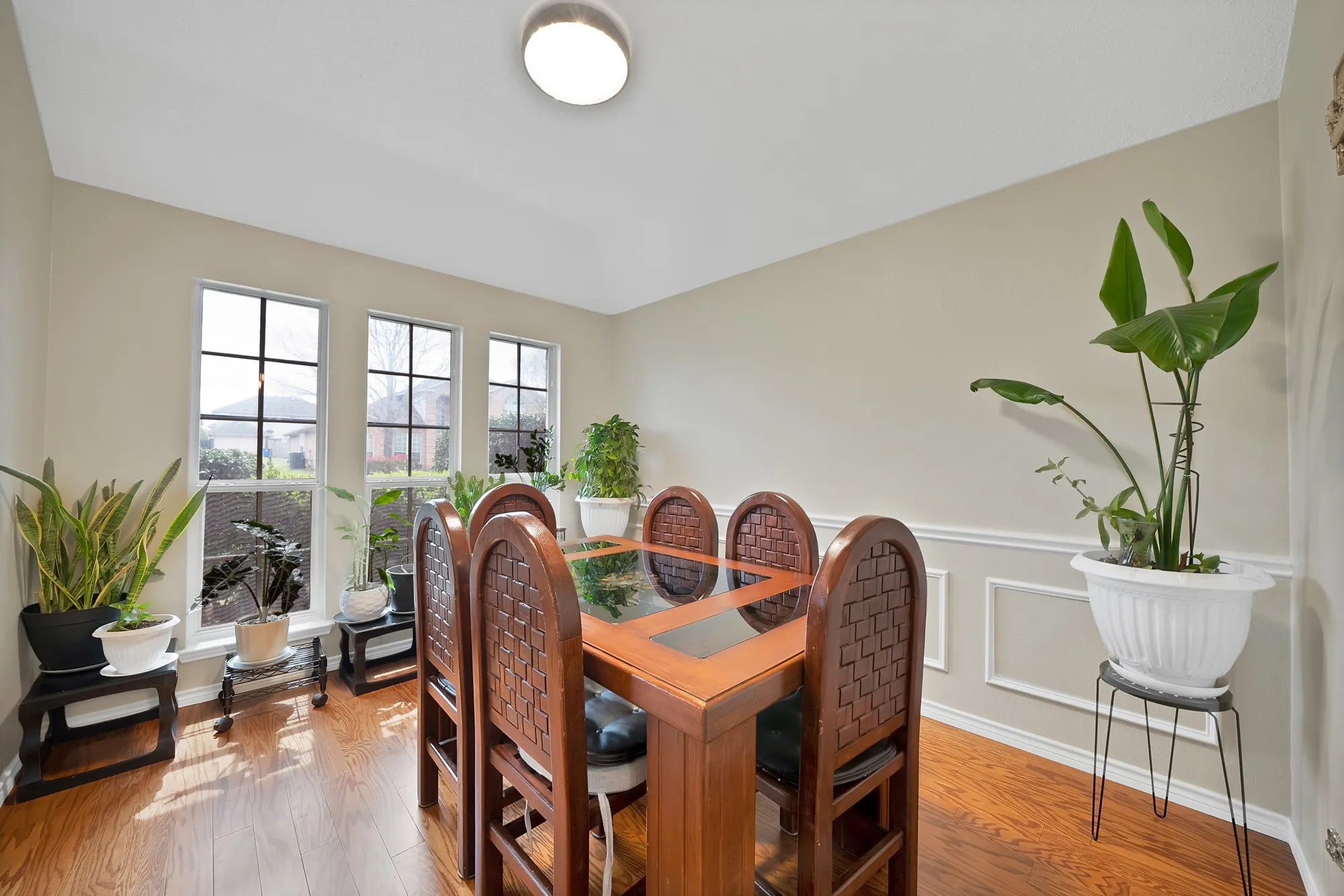 Dining area with light wood-style floors and a wainscoted wall